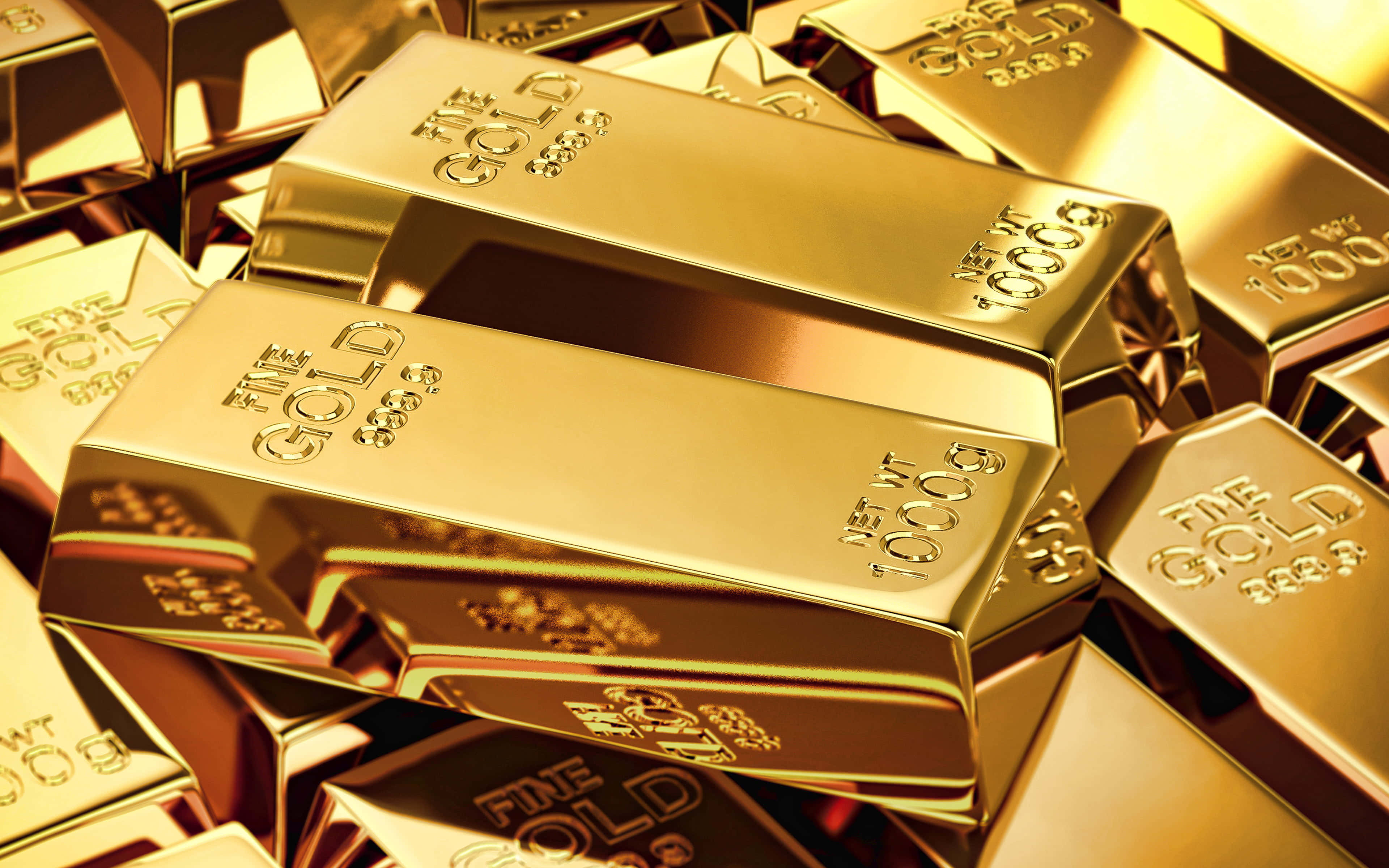 Shiny Gold 桌布 壁紙 — 堆疊閃亮金條，帶有雕刻標記，在特寫鏡頭中反射溫暖光線。