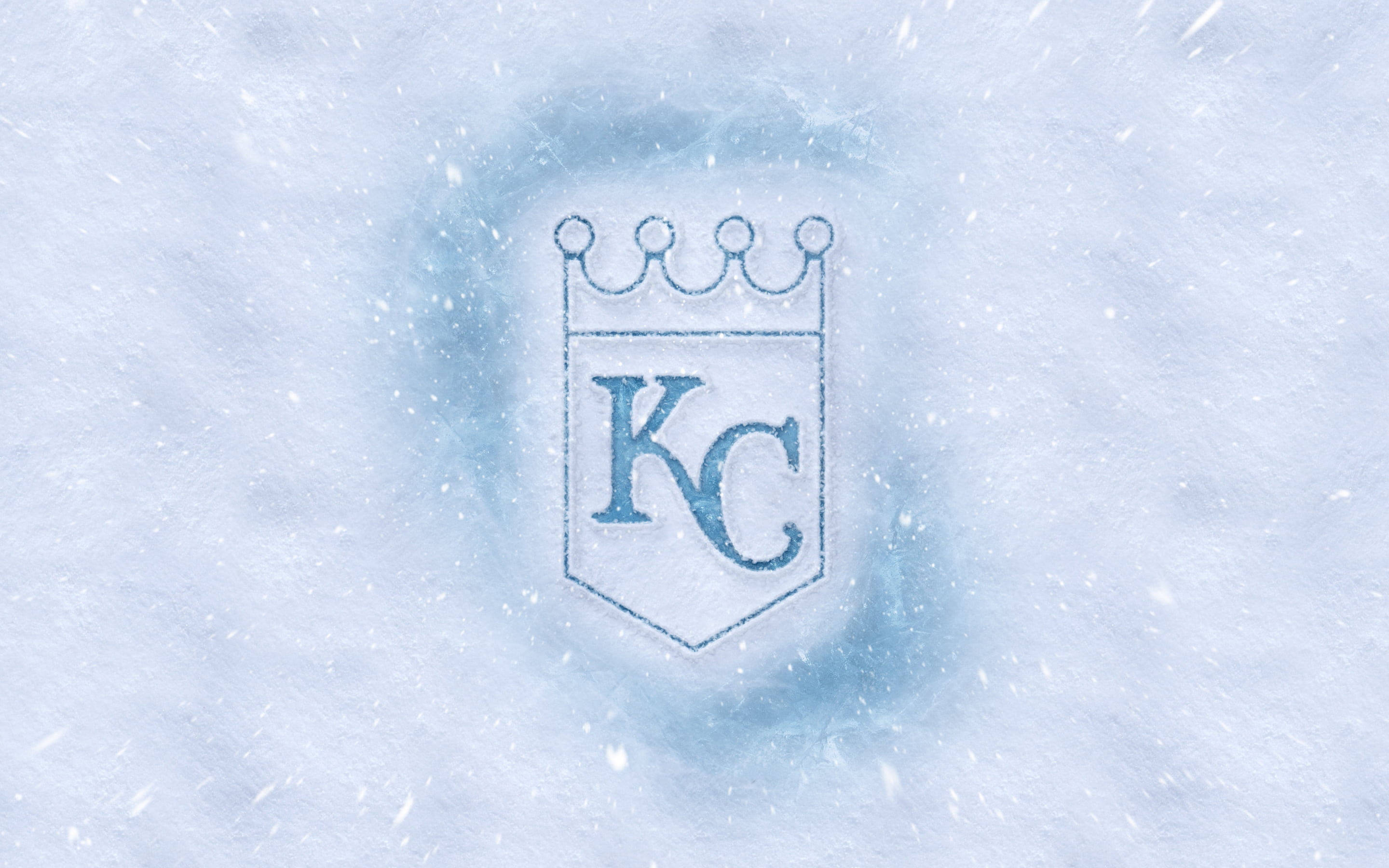 Kansas 桌布 壁紙 — 堪薩斯城皇家隊標誌刻在雪中，飄落的雪花在其冰冷盾牌周圍旋轉。