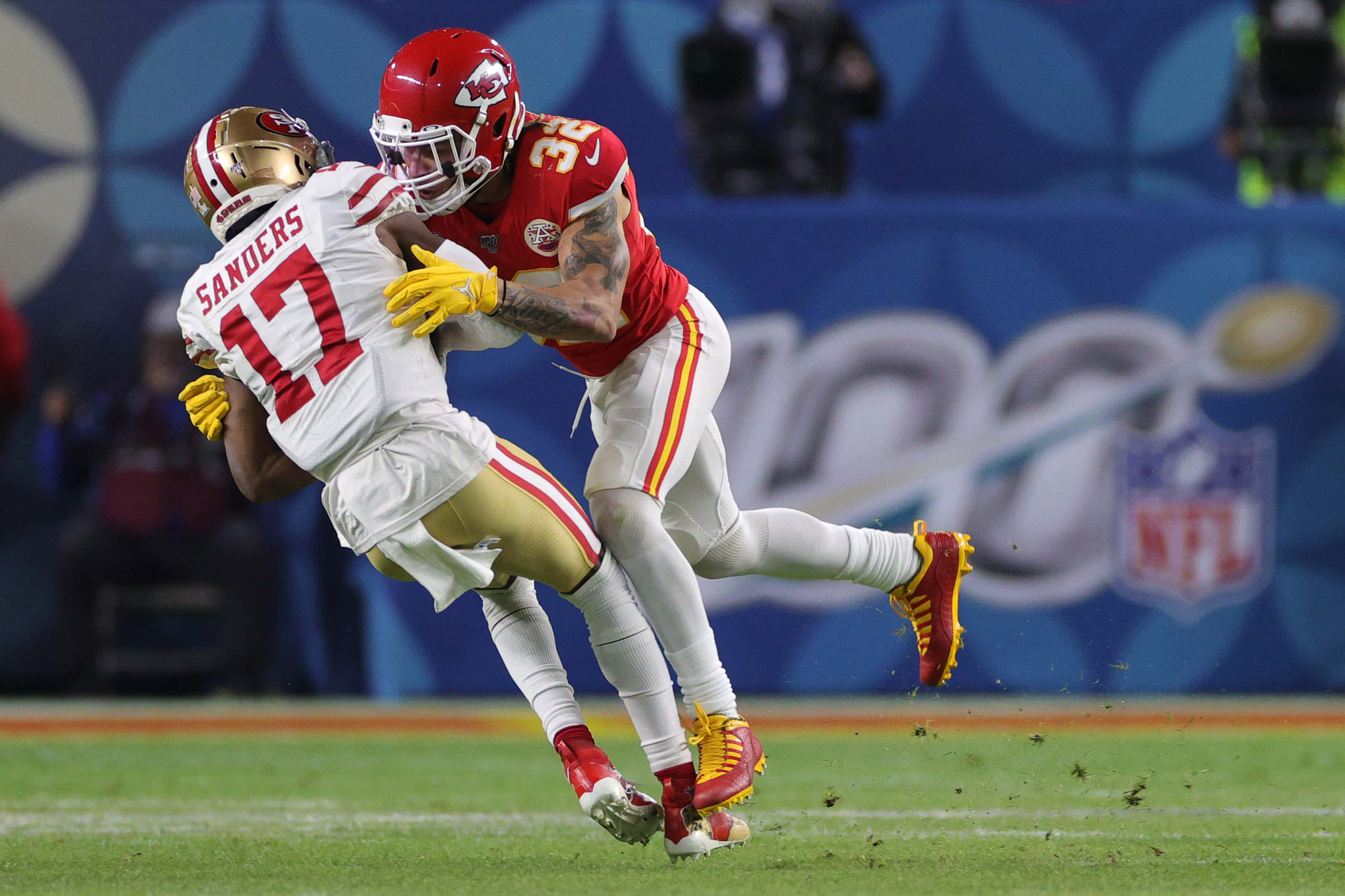 Tyrann Mathieu 桌布 壁紙 — 堪薩斯城酋長隊的線衛在體育場燈光下的一場激烈NFL比賽中擒抱了舊金山49人隊的跑衛。