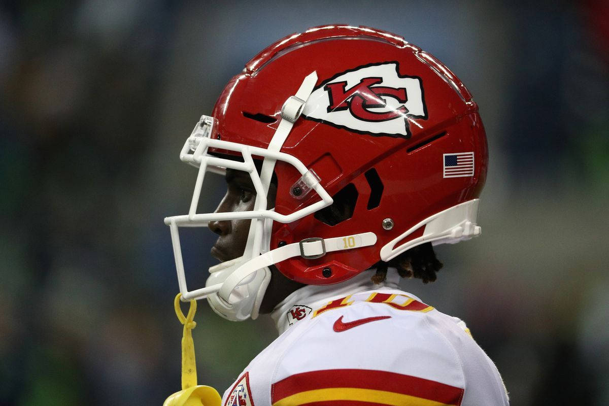 Tyreek Hill 桌布 壁紙 — 堪薩斯城酋長隊美式足球員的近距離特寫，戴紅色頭盔、穿白色球衣，在比賽中望向場外。