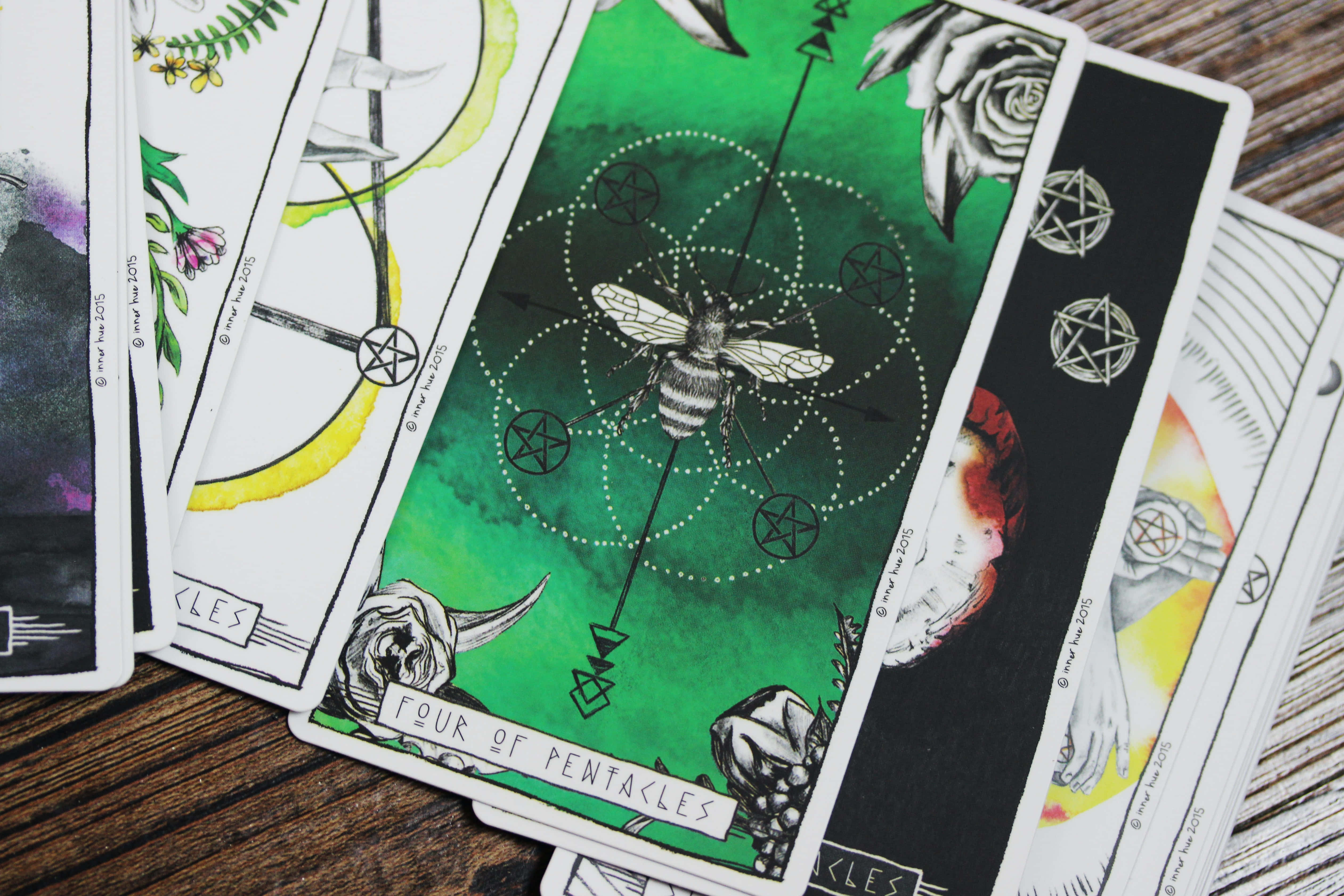 Tarot Card 桌布 壁紙 — 塔羅牌帶有神秘符號和中央蜜蜂插圖，放置在質樸的木質表面上。