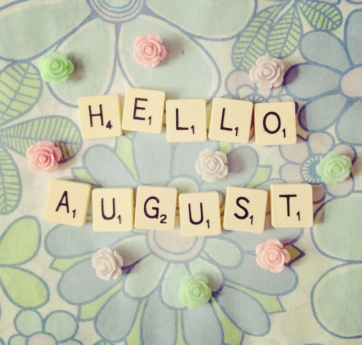 August 桌布 壁紙 — 塗鴉的scrabble tiles拼出hello august，周圍是細小的粉彩玫瑰，背景是花卉布料。