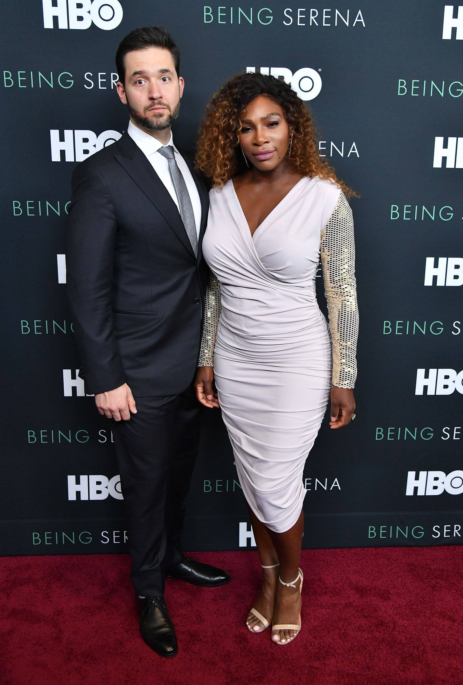 Serena 桌布 壁紙 — 塞雷娜·威廉姆斯和她的伴侶在HBO《Being Serena》首映典禮的紅地毯上優雅地擺姿勢，背景帶有品牌標誌。