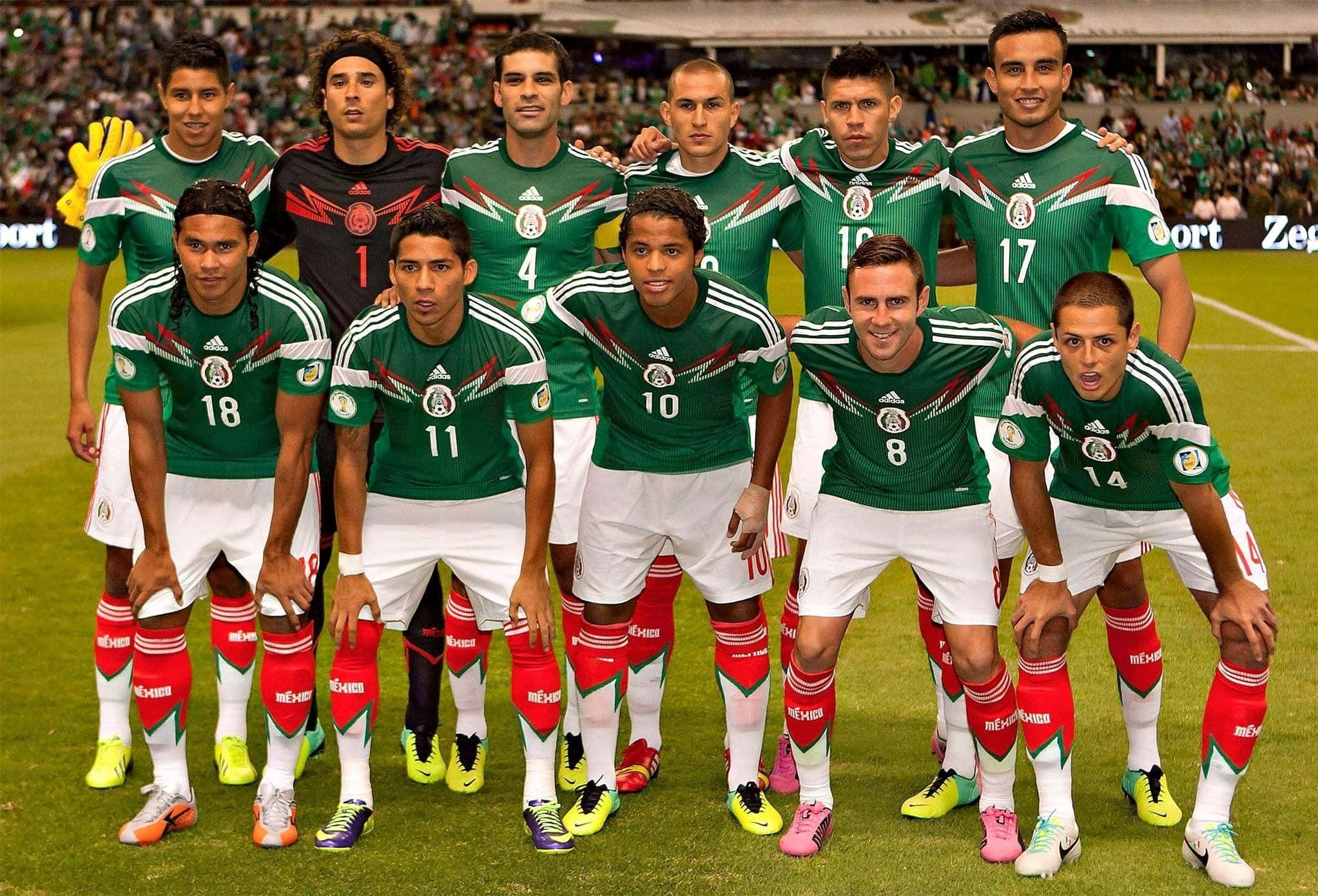 Mexico Soccer 桌布 壁紙 — 墨西哥國家足球隊在球場燈光下，於充滿活力的綠色球場上穿著綠、白、紅三色球衣擺姿勢。