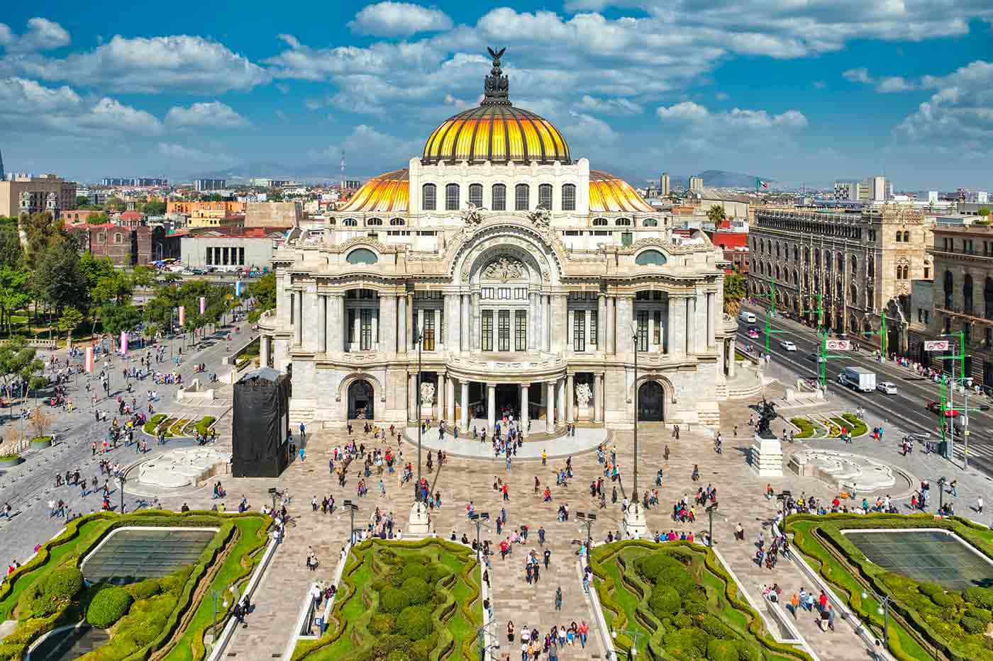 墨西哥 桌布 壁紙 — 墨西哥城宏偉的新古典主義藝術宮（Palacio de Bellas Artes）的鳥瞰圖，金色圓頂和繁忙的廣場在明亮的藍天下。