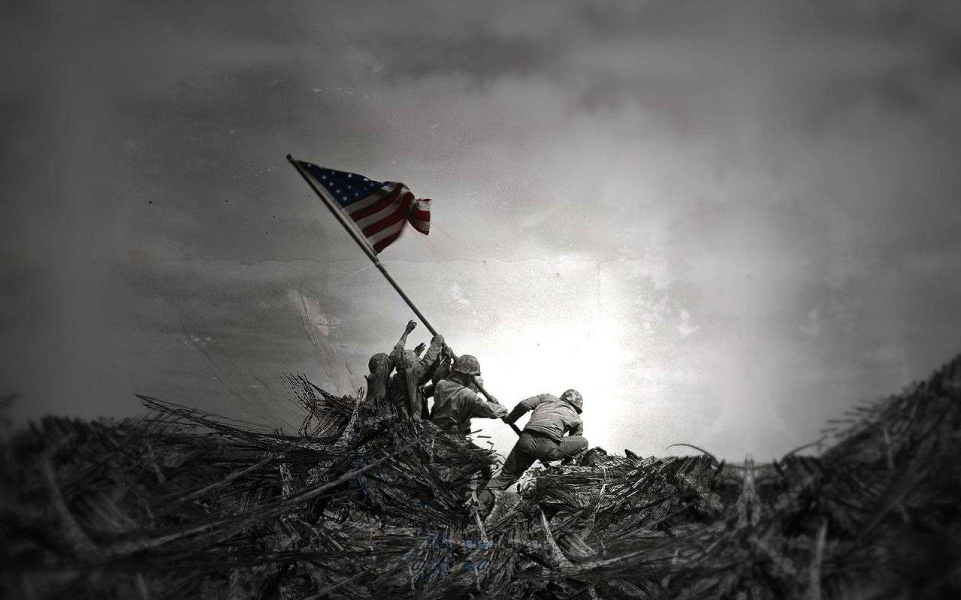 Veterans 桌布 壁紙 — 士兵們在戲劇性的多雲天空下，在崎嶇的戰場上舉起美國國旗。