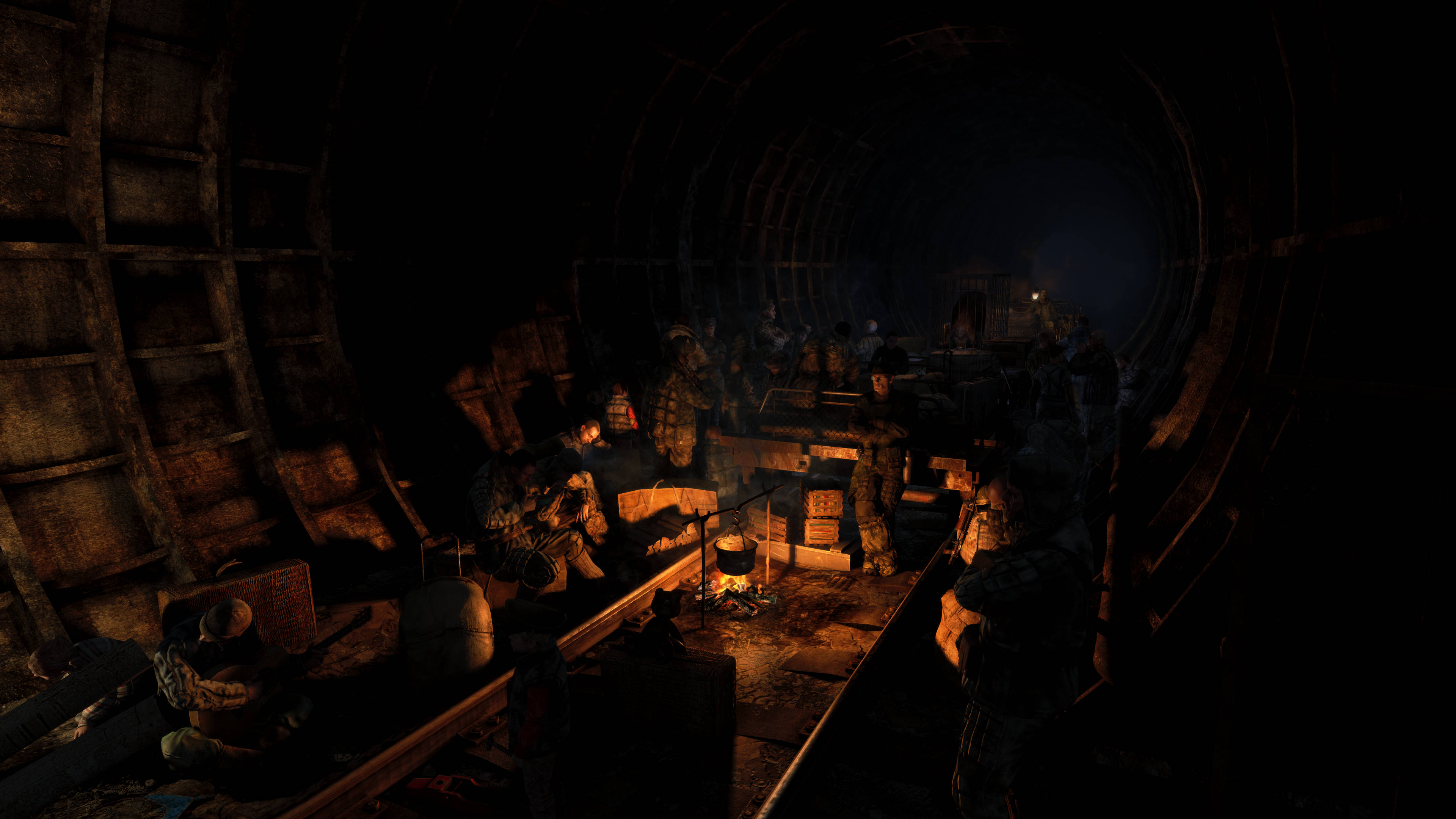 Metro 2033 桌布 壁紙 — 士兵們擠在一個昏暗、生鏽的金屬隧道內的營火周圍，閃爍的橙色燈光投下陰影。