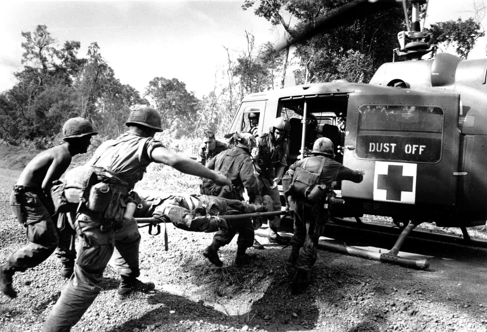 Vietnam War 桌布 壁紙 — 士兵們緊急地用擔架抬著一名受傷的戰友，走向叢林空地上的「Dust Off」醫療直升機。