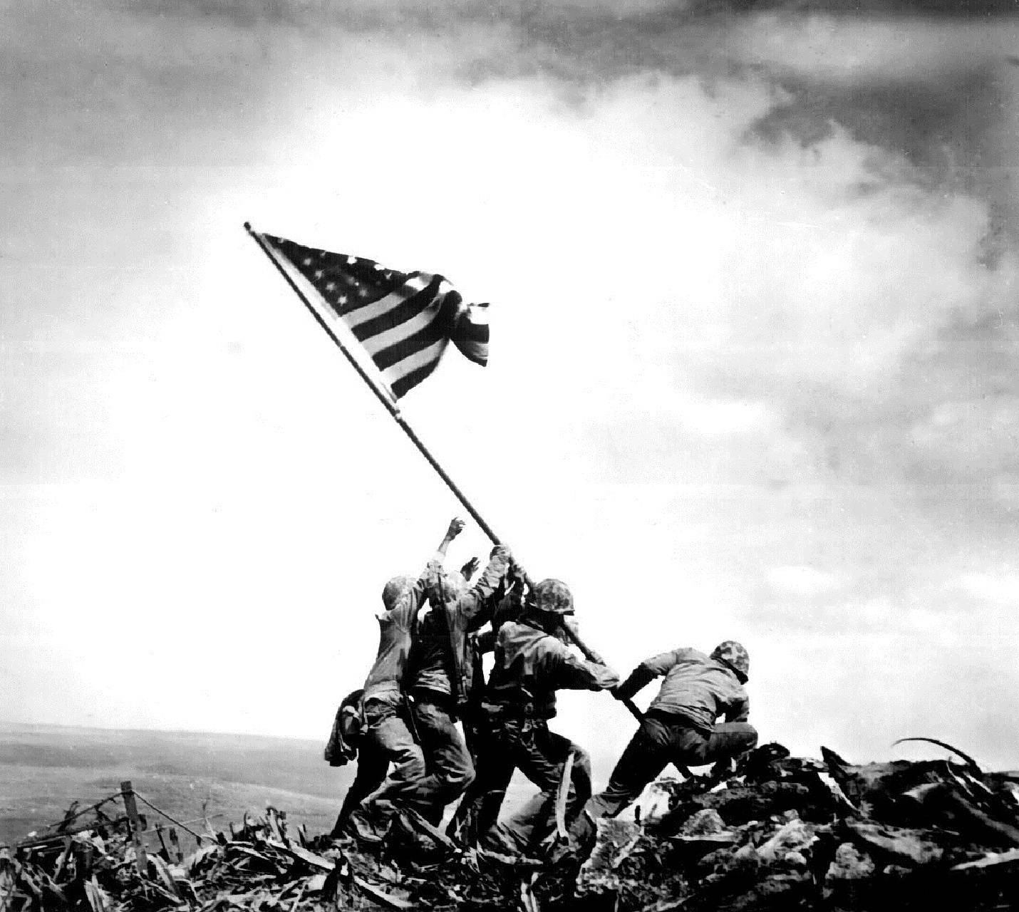 US 桌布 壁紙 — 士兵在陰天下於戰場山脊升起美國國旗的歷史黑白照片。