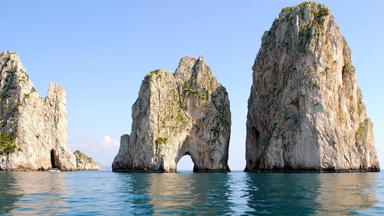 Capri 桌布 壁紙 — 壯觀的海蝕柱帶有天然拱門，從碧綠的海水中升起，在清澈的藍天下。