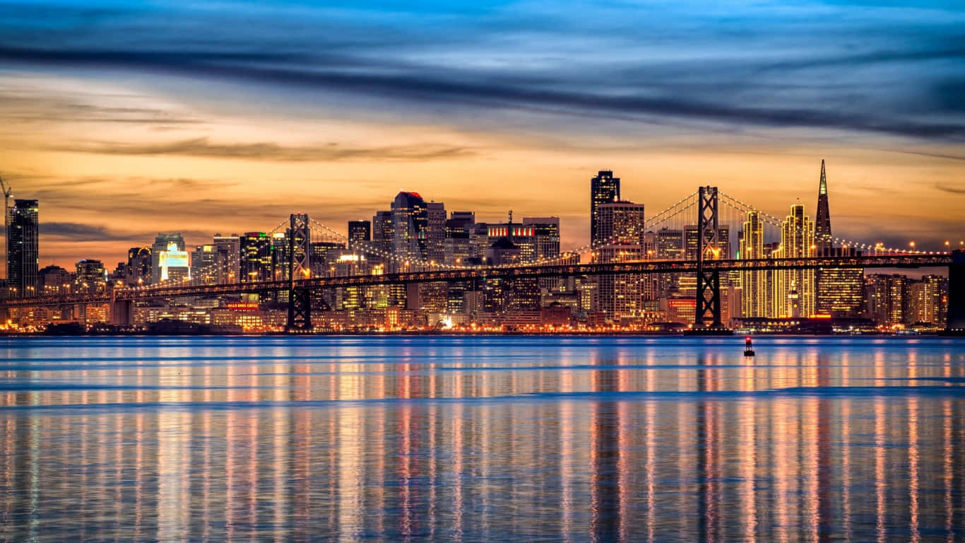 1366x768 San Francisco 桌布 壁紙 — 壯麗的日落映照城市天際線，橋樑在平靜的水面上倒映，天空雲彩變幻莫測。