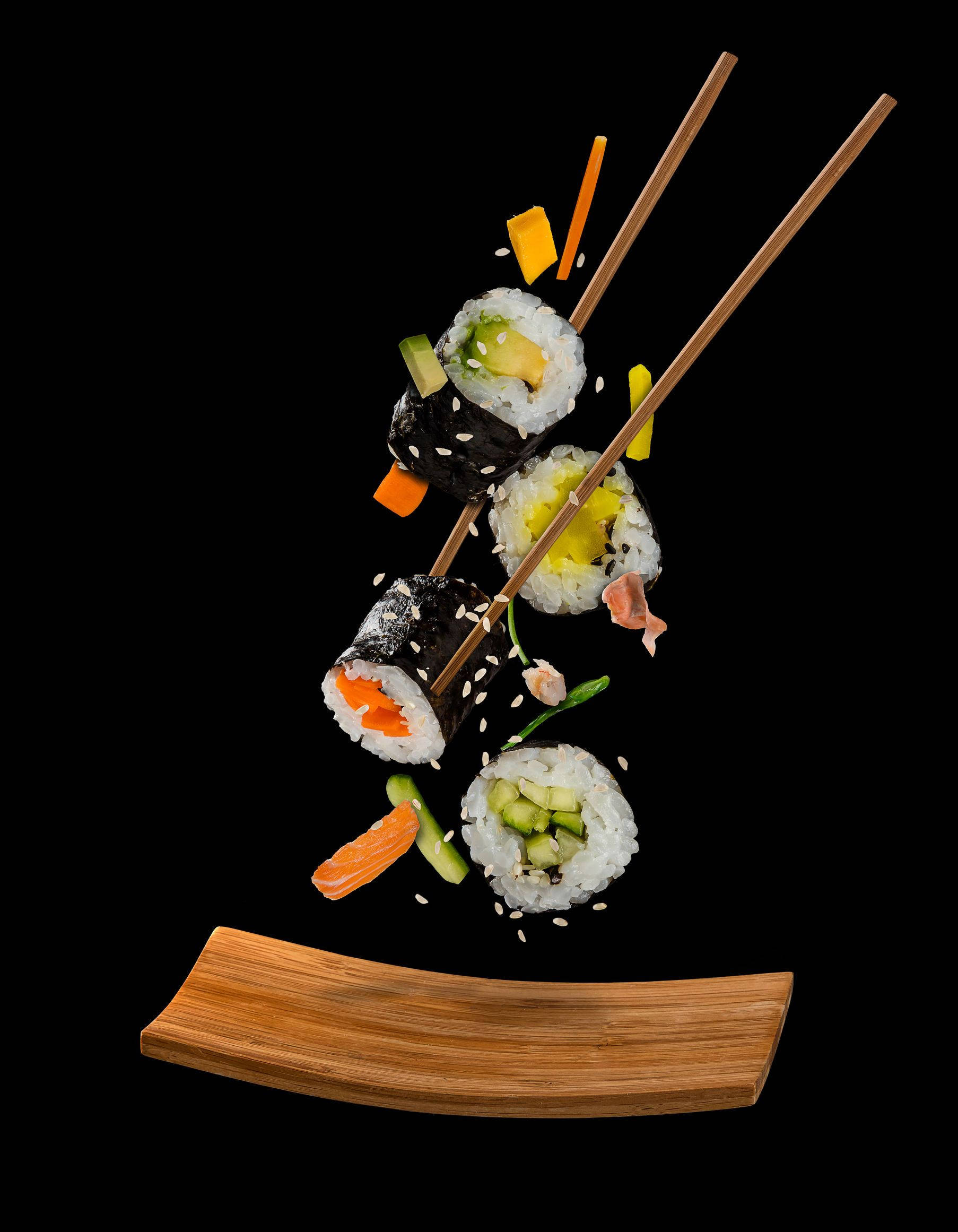 Sushi 桌布 壁紙 — 壽司卷和筷子懸浮在黑色背景的木盤上方。