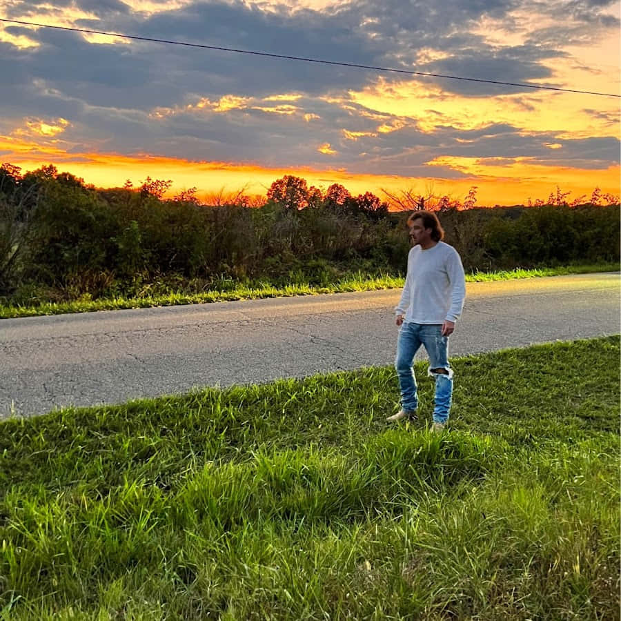 夕陽下站在路邊的男人 壁紙
