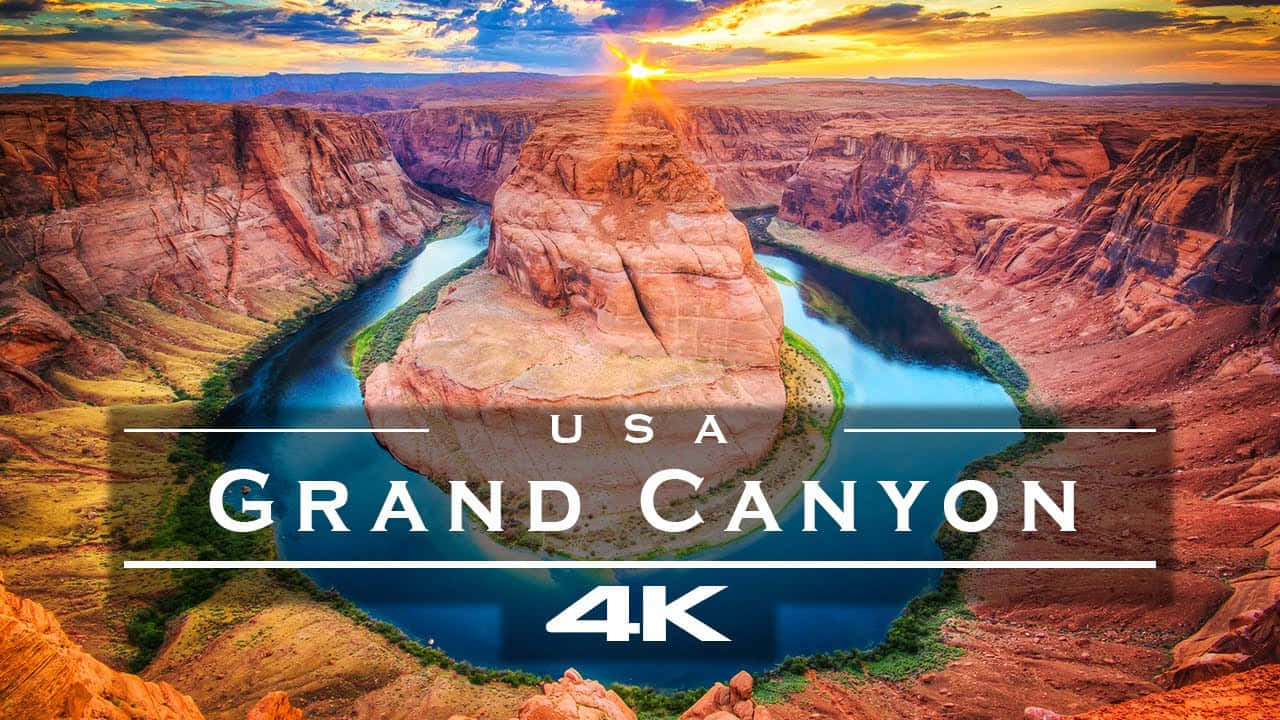 grand canyon 桌布 壁紙 — 夕陽以大峽谷的溫暖色調沐浴，河流蜿蜒穿過其紅色岩層。