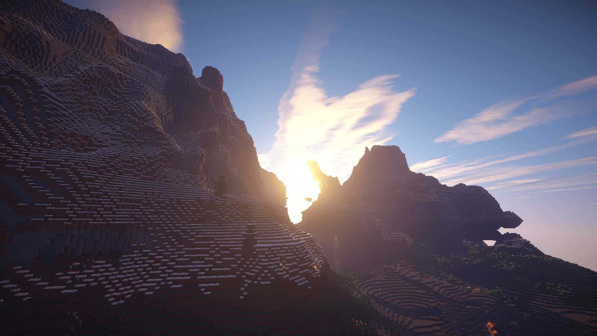 Minecraft Shaders 桌布 壁紙 — 夕陽在像素化Minecraft景觀中的塊狀山峰之間發光，伴隨著縷縷雲彩。