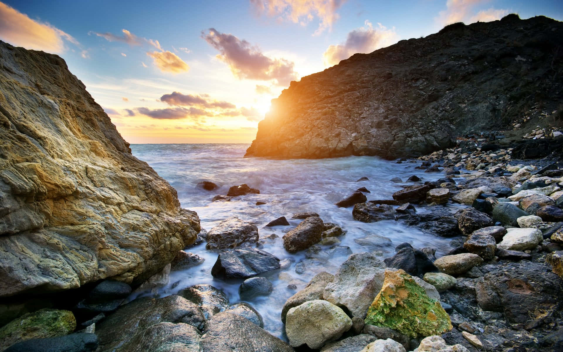 Beautiful Landscape 桌布 壁紙 — 夕陽在懸崖後發光，海浪拍打岩石，形成戲劇性的海岸場景。