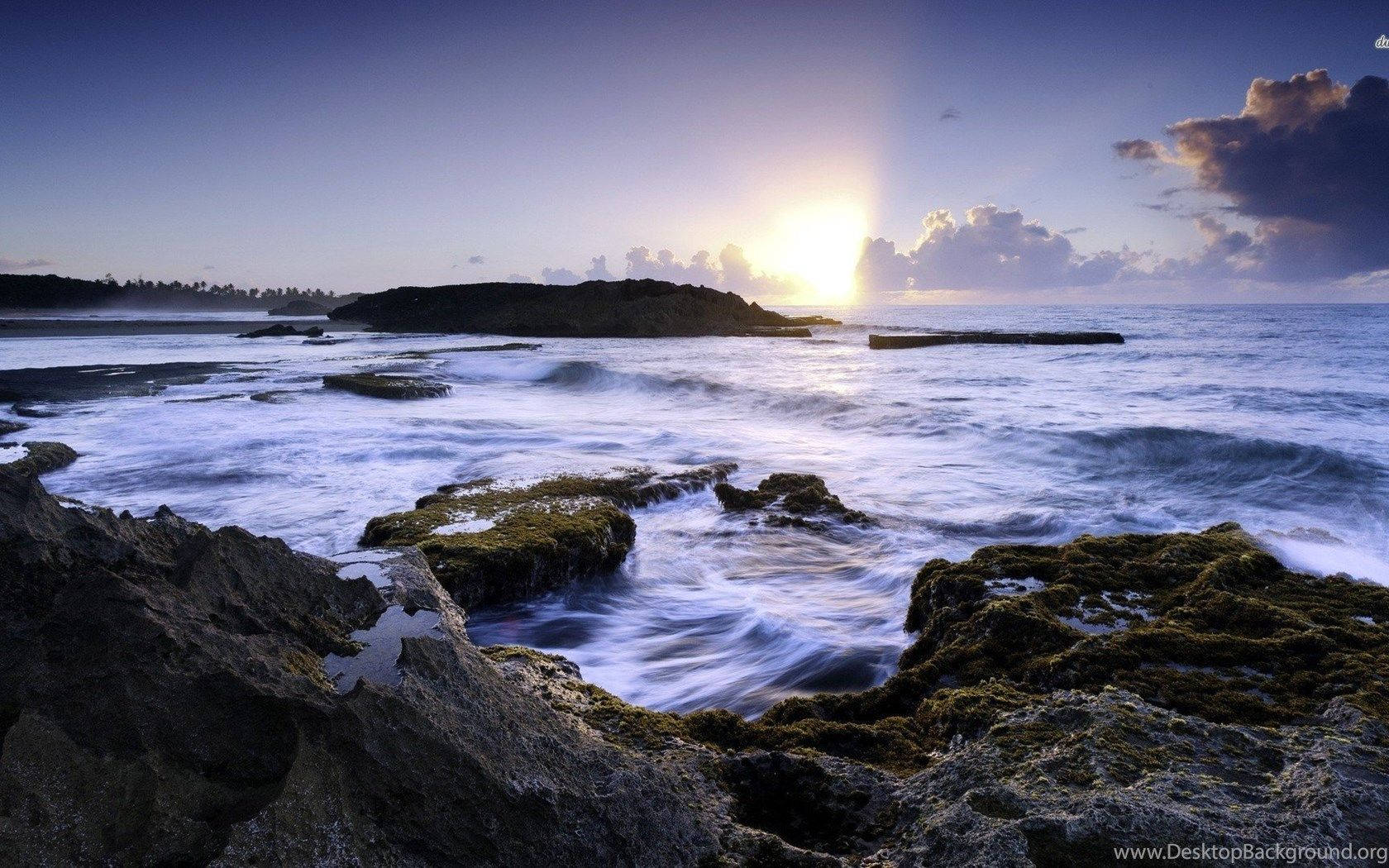 波多黎各 桌布 壁紙 — 夕陽在海浪拍打長滿苔蘚的岩石的寧靜海岸場景中閃耀。