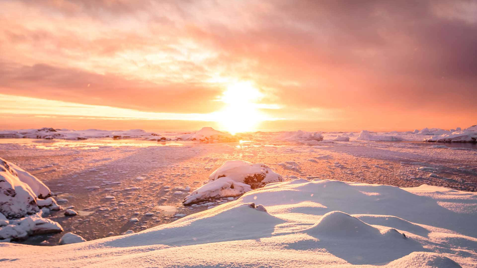 南極洲 桌布 壁紙 — 夕陽將冰凍的北極景觀上的冰水和雪堆染成火熱的橙色和粉紅色調。