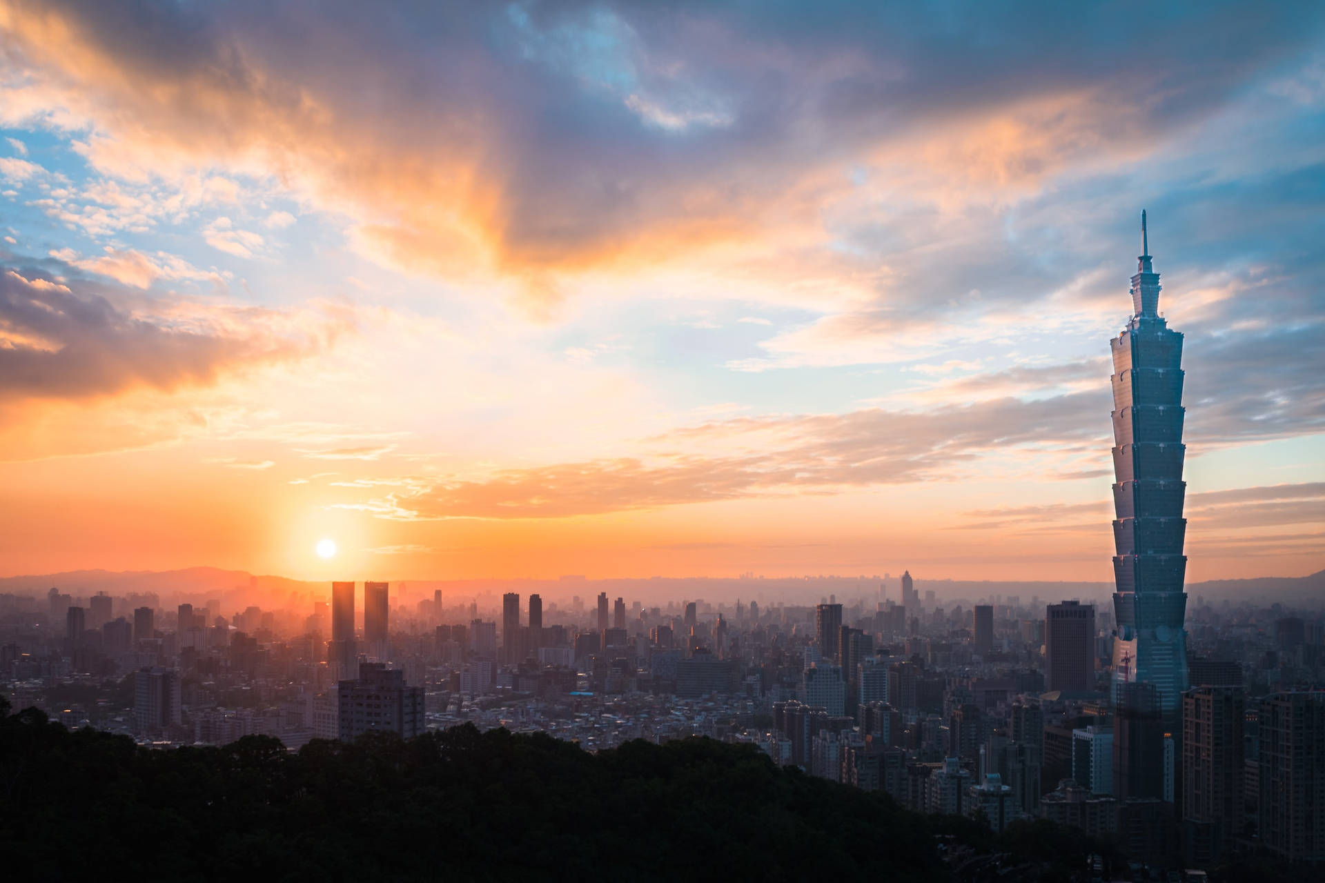 台北城市景觀上的夕陽，台北101大樓在色彩繽紛的天空中格外突出。