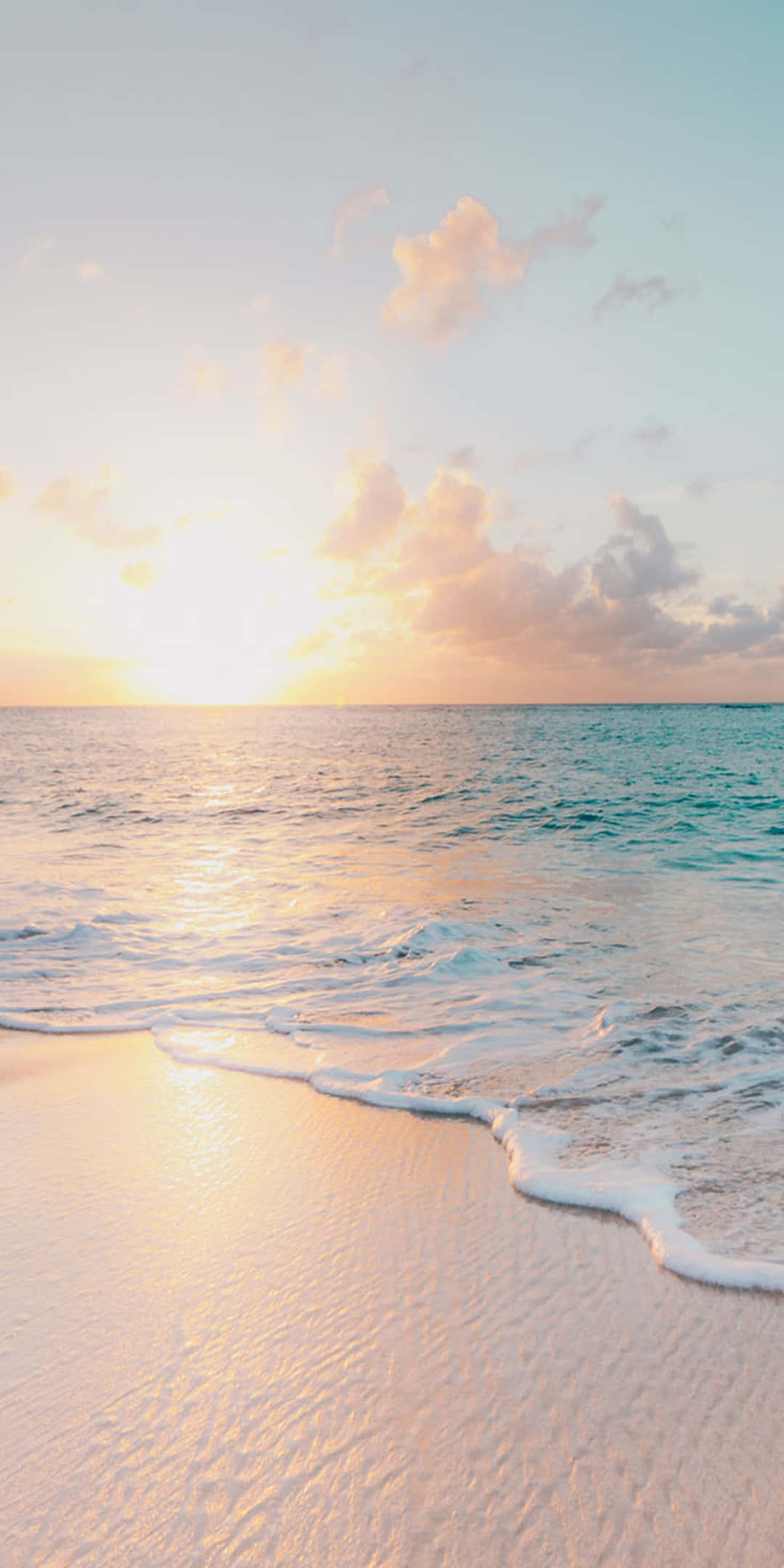 Pixel 3 Summer 桌布 壁紙 — 夕陽將天空和海洋染成溫暖的金色和粉紅色，溫柔的海浪輕吻著沙灘。
