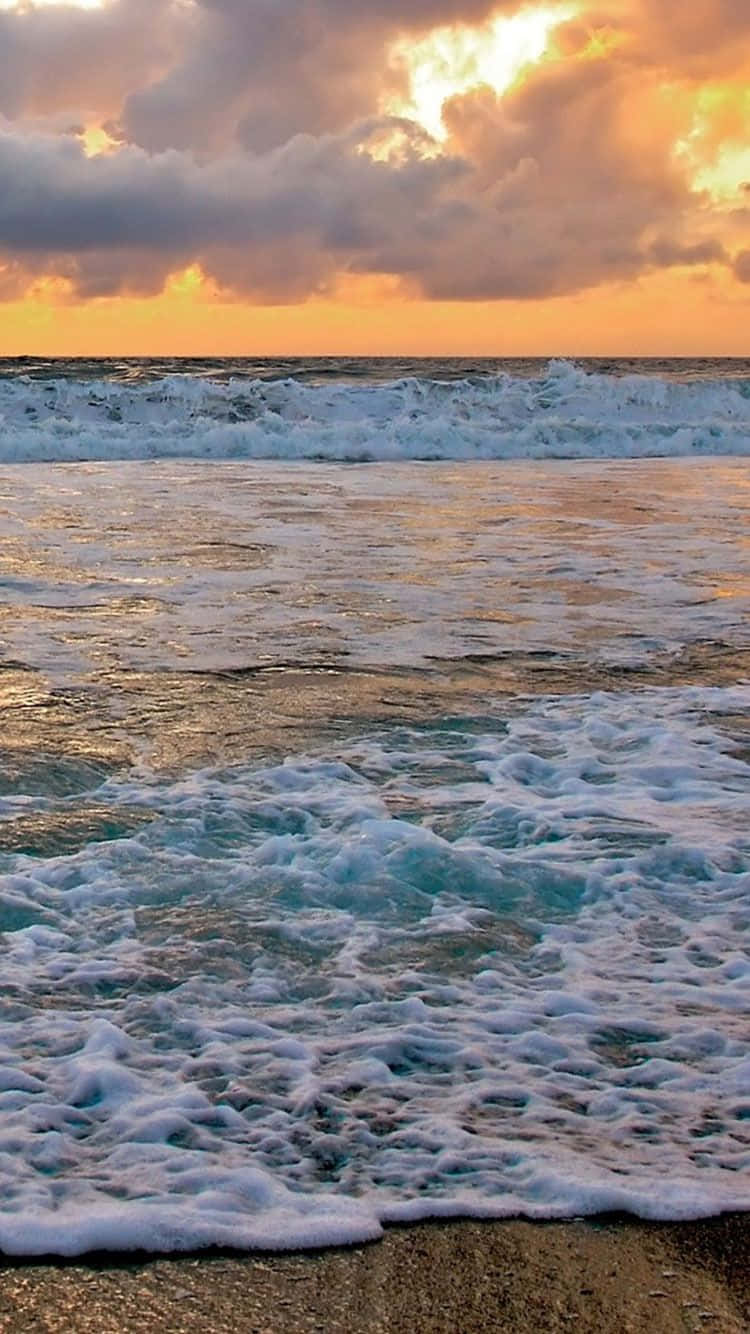 桌布 壁紙 — 夕陽將天空染成火熱的橙色，翻騰的海浪在沙灘上泛起泡沫。