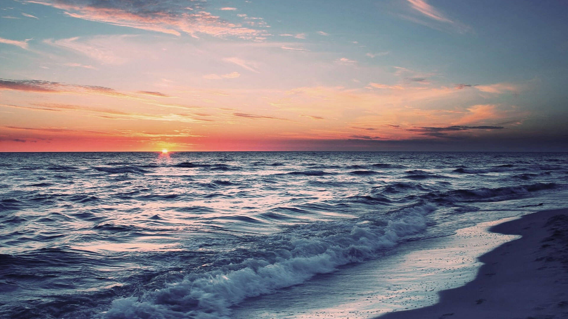 Chennai 桌布 壁紙 — 夕陽將天空染成火熱的橙色和粉紅色，海浪在黃昏時拍打沙灘。