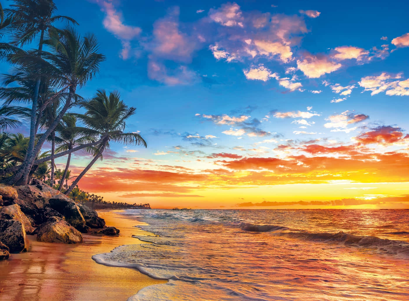 paradise 桌布 壁紙 — 夕陽將天空染成火熱的橙色和粉紅色，海浪拍打著佈滿傾斜棕櫚樹的沙灘。