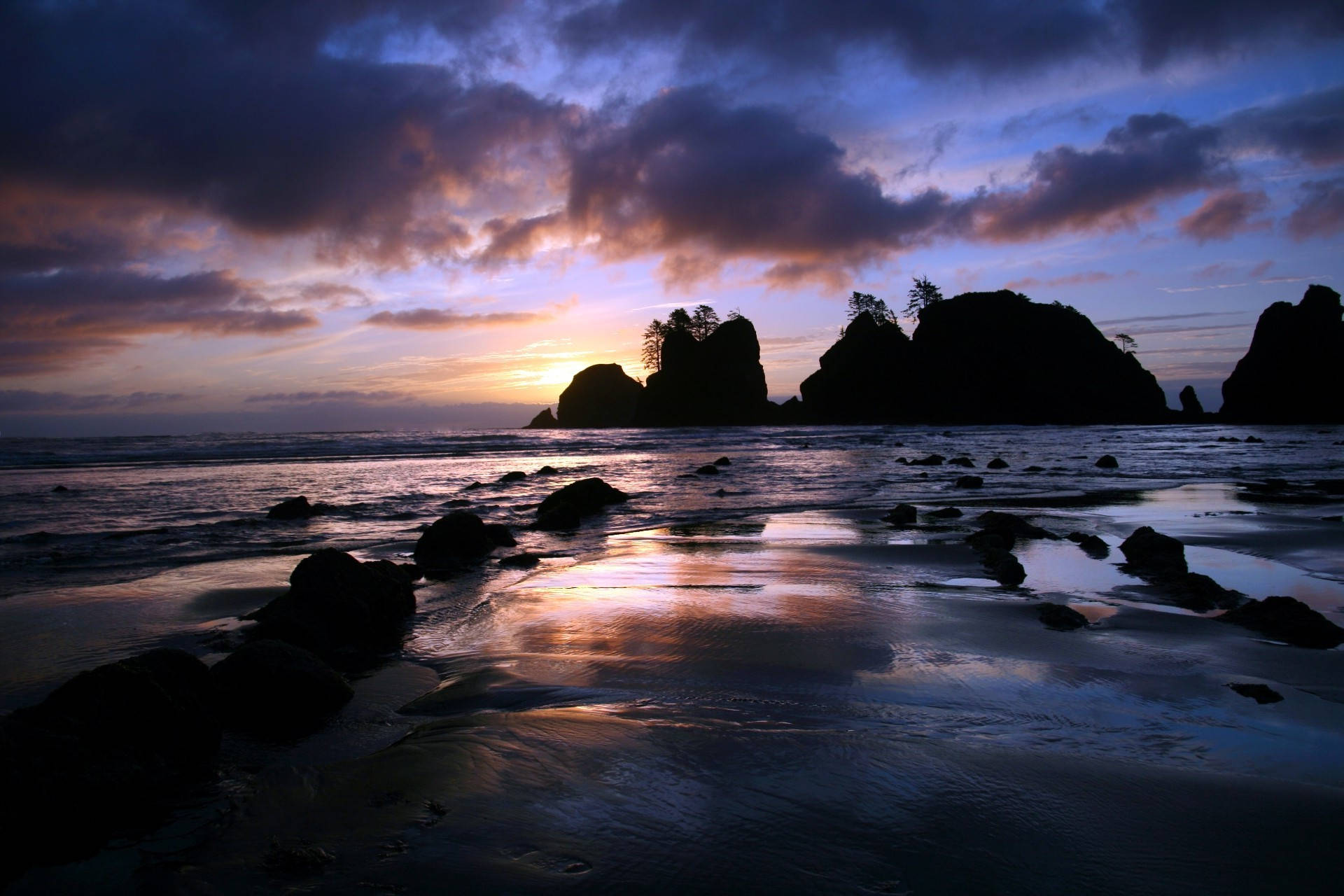 Tumblr Sunset Desktop 桌布 壁紙 — 夕陽將天空染成紫色和橙色，海浪拍打岩石海灘，海蝕柱形成剪影。