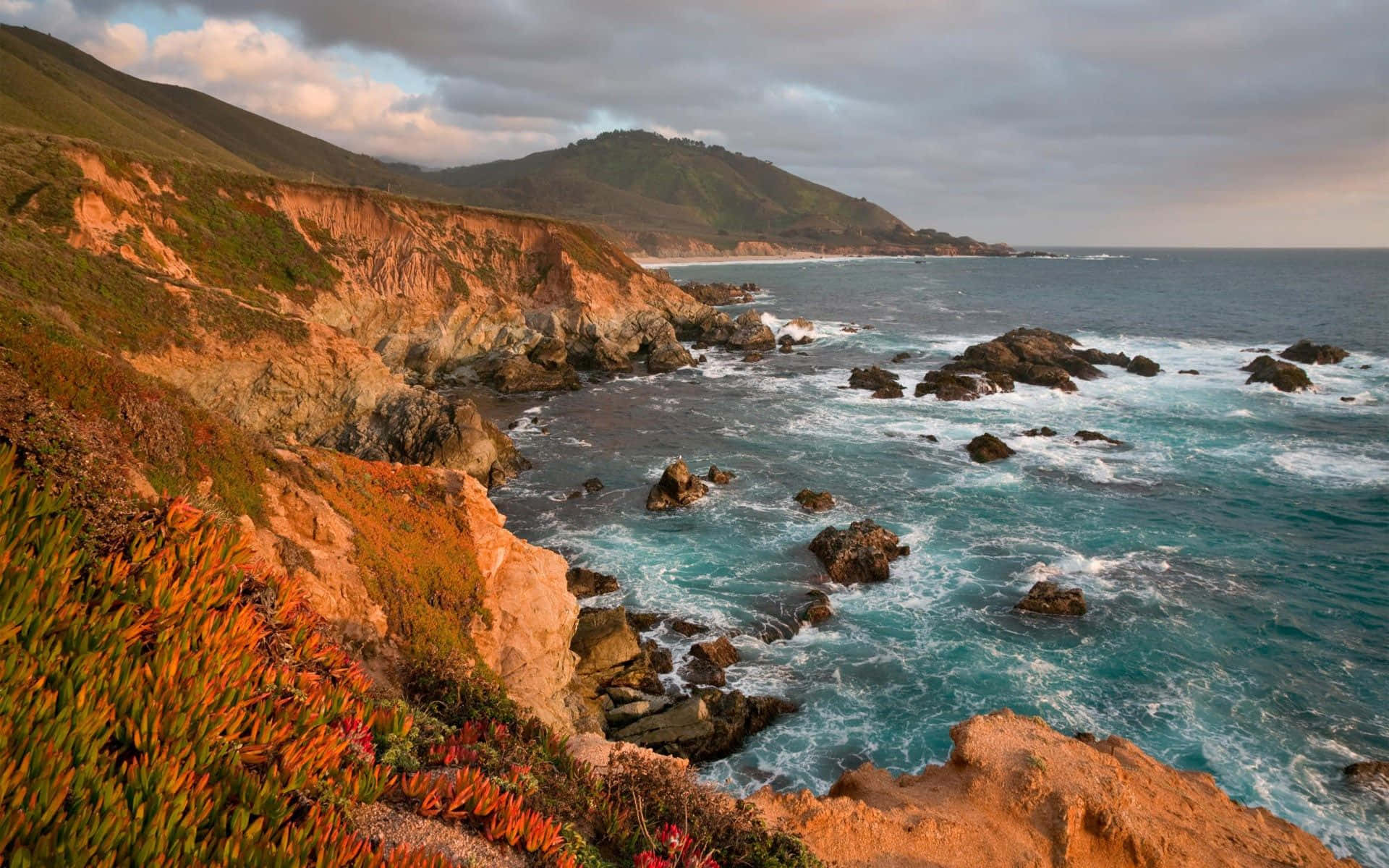 Coastline 桌布 壁紙 — 夕陽將懸崖和破碎的碧綠海浪染成火橙色和深藍色調。