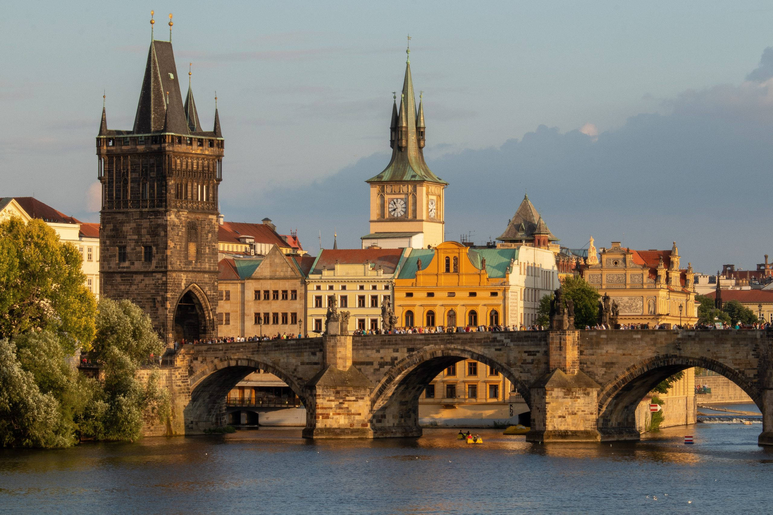 Europe 桌布 壁紙 — 夕陽將歷史悠久的查理大橋和布拉格天際線沐浴在伏爾塔瓦河上的金色光芒中。