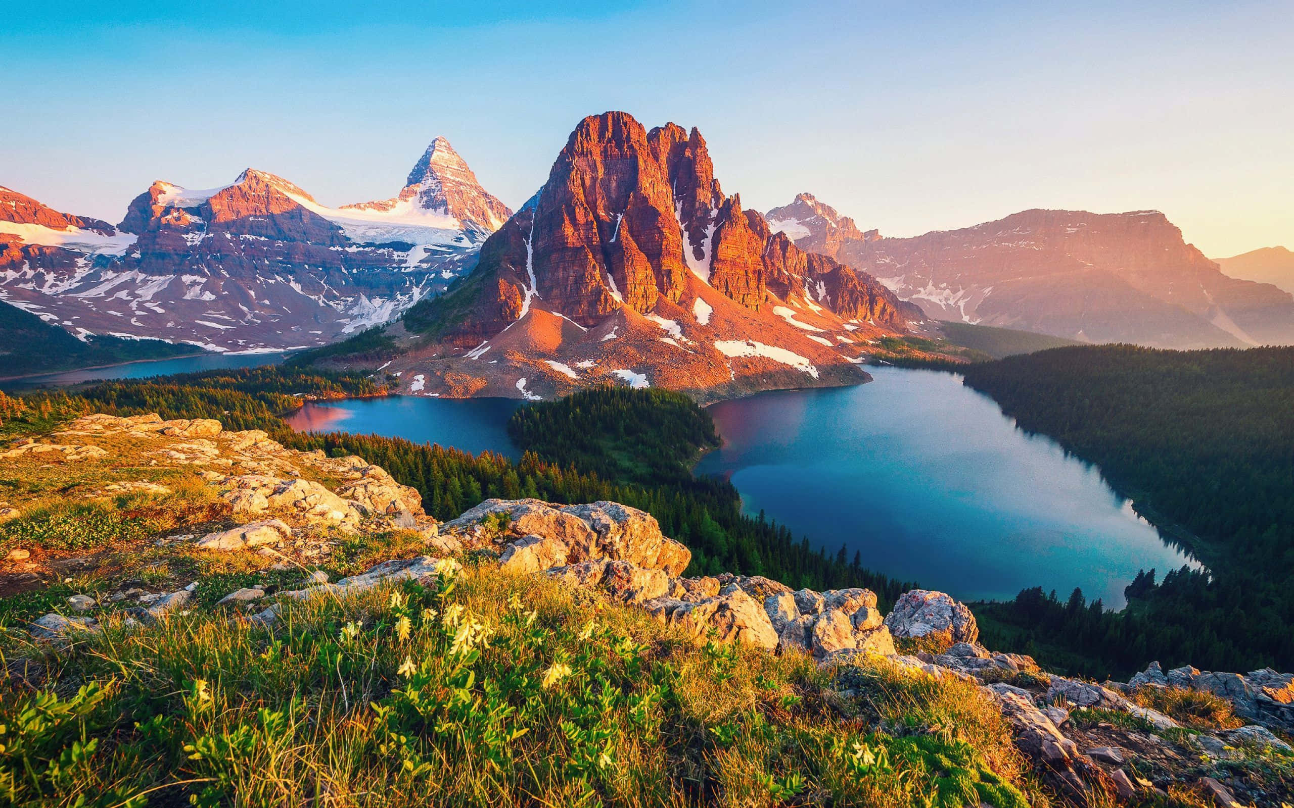 Mountain Landscape 桌布 壁紙 — 夕陽將鋸齒狀的雪山和寧靜的高山湖泊沐浴在溫暖的金色光芒中。