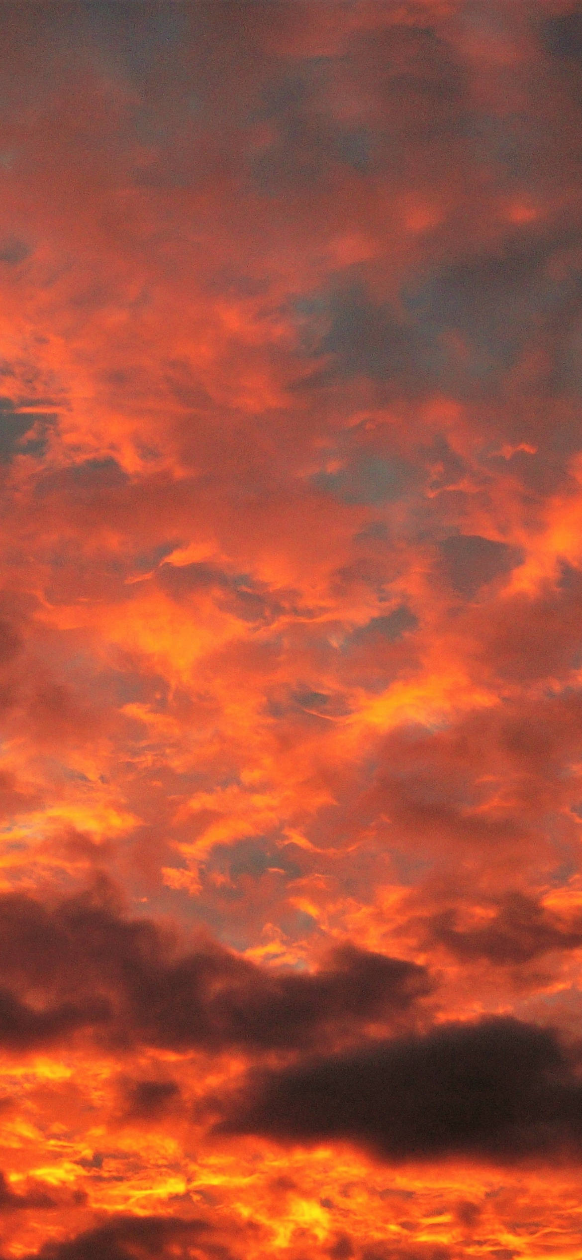 Clouds Aesthetics 桌布 壁紙 — 夕陽或日出時，天空被火熱的橙色和紅色雲彩點燃，景象壯觀。