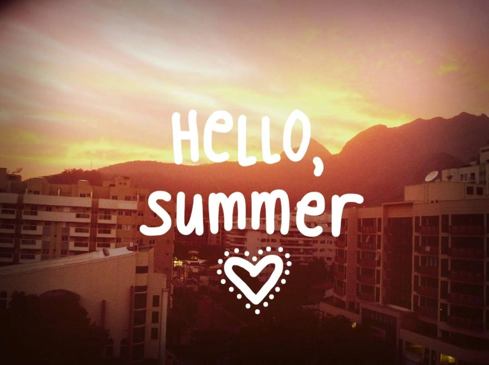 Hello 桌布 壁紙 — 夕陽映照城市屋頂，背景有山巒，並覆蓋 'hello summer' 文字。