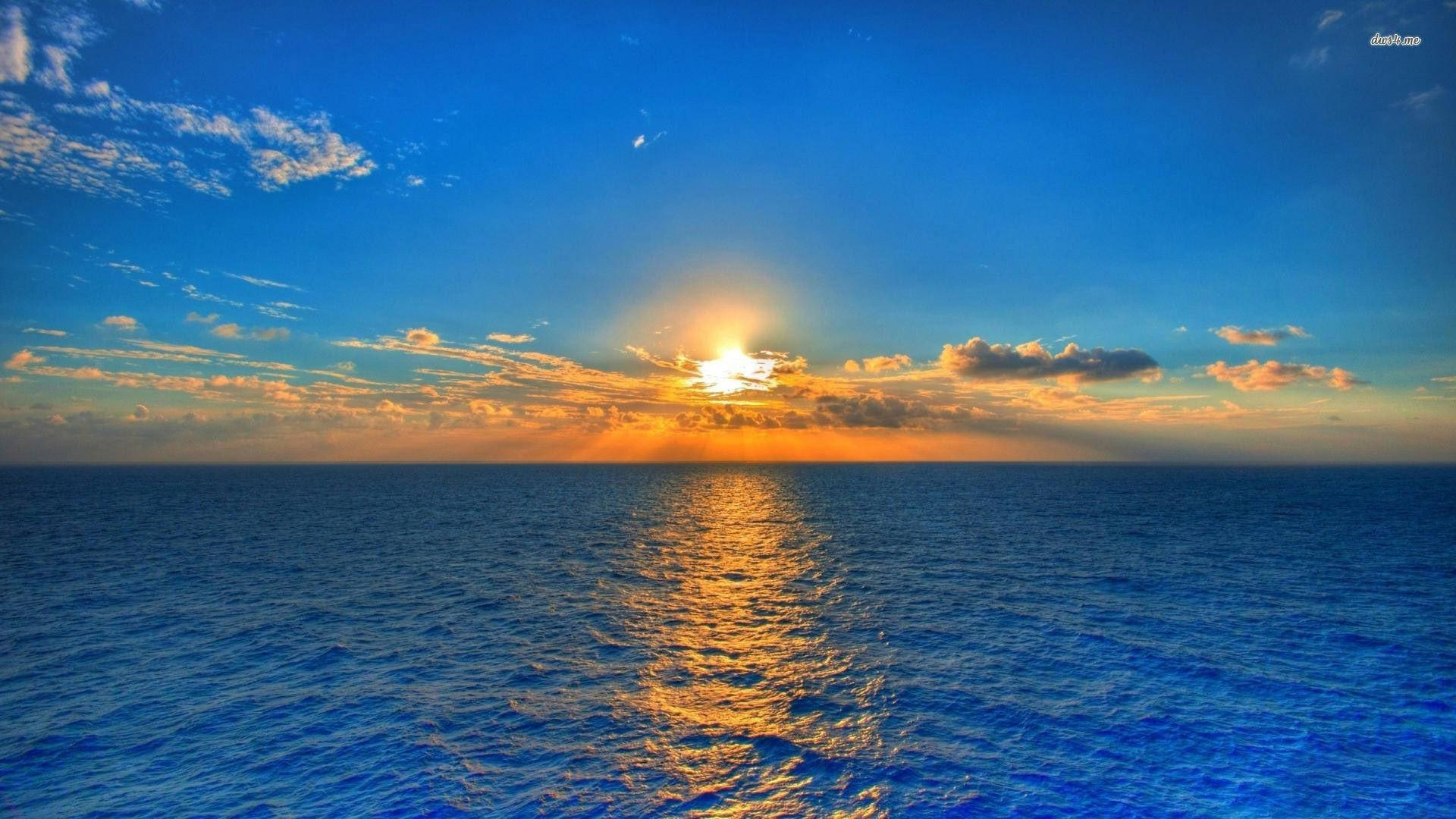 平靜海洋上的夕陽，金色光芒反射在水面和散落的雲朵上。 — 3D 桌面 GIF 壁紙