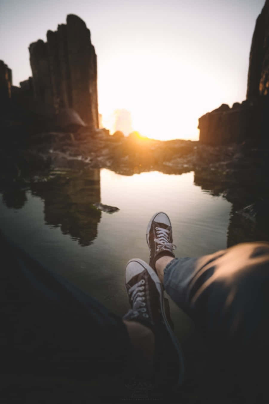 夕陽時分，一雙人腳坐在水面 壁紙