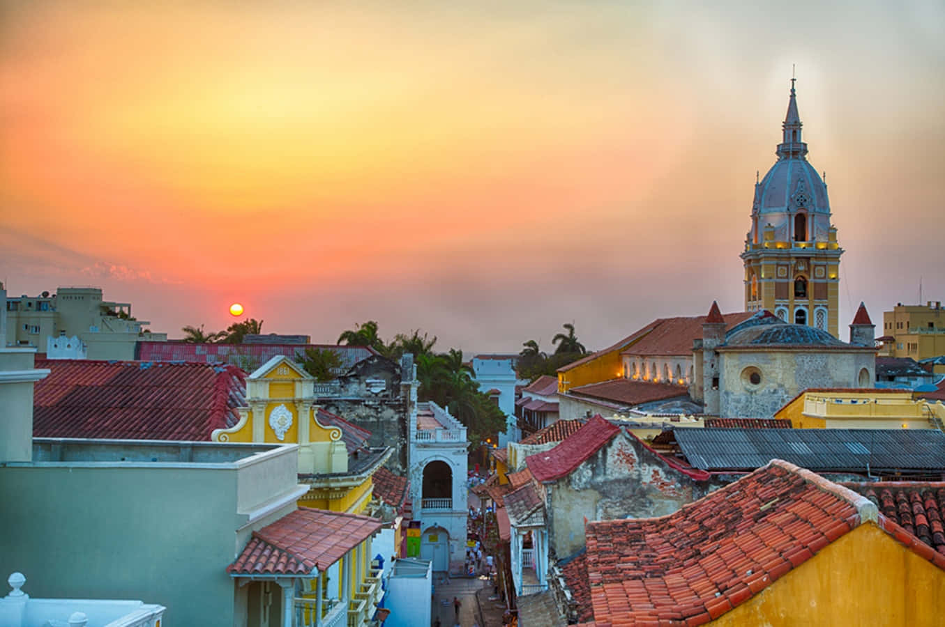 Colombia 桌布 壁紙 — 夕陽為充滿活力的拉丁美洲城市中色彩繽紛的殖民時期屋頂和歷史悠久的教堂塔樓塗上一層溫暖的光芒。