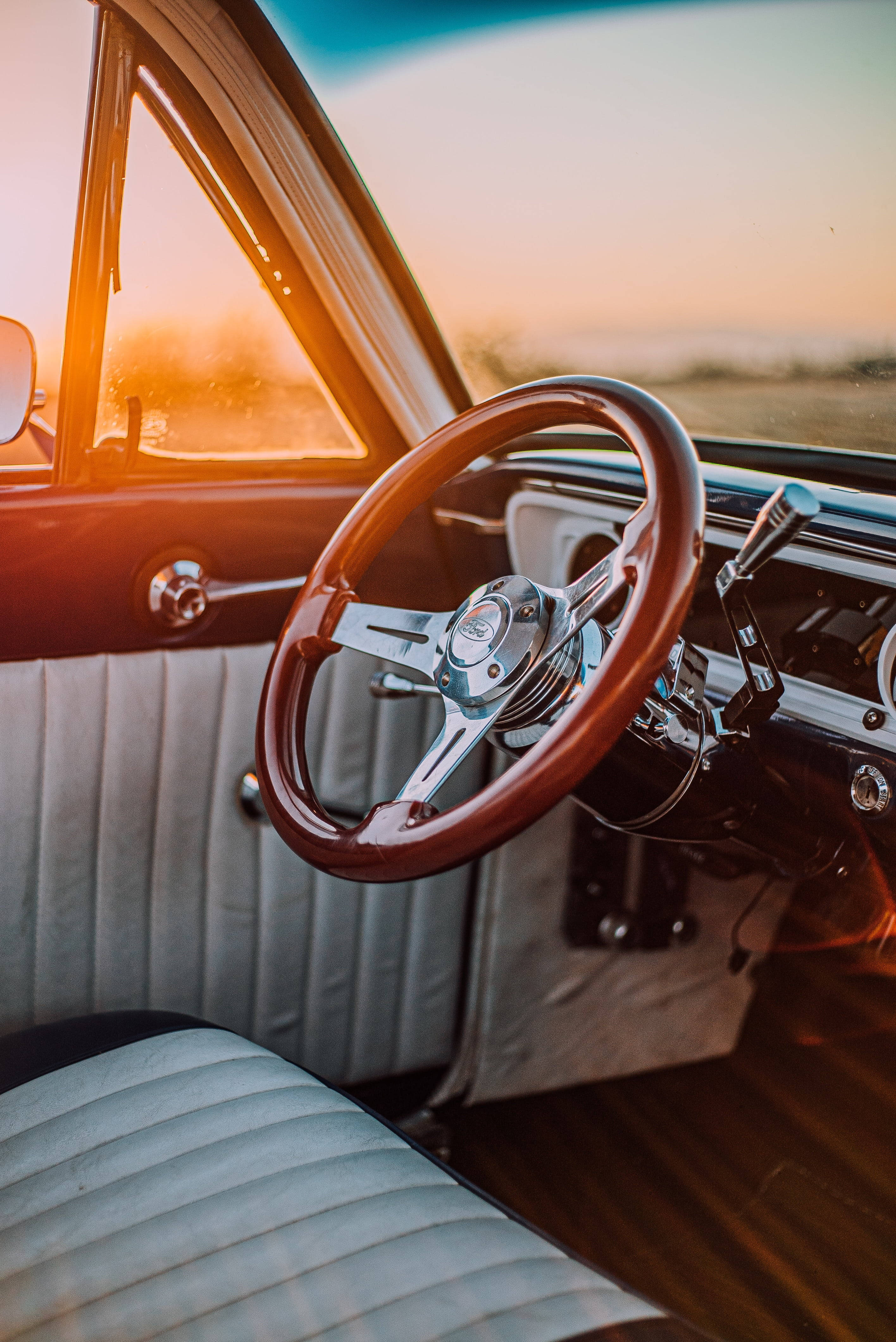 Retro Aesthetic 桌布 壁紙 — 夕陽的餘暉將復古車的木質方向盤和鍍鉻儀表板沐浴在溫暖的琥珀色光中。