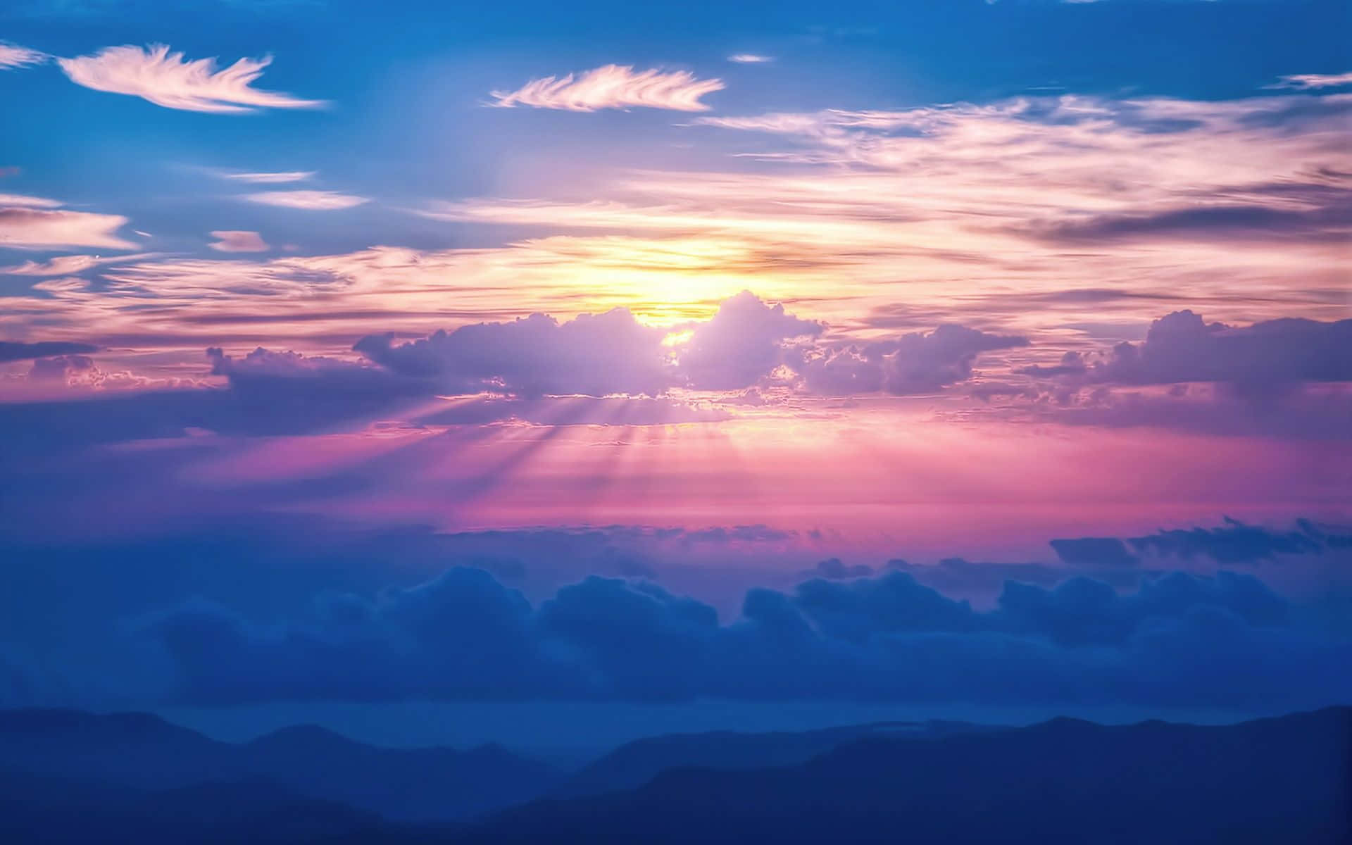 Sky Clouds 桌布 壁紙 — 夕陽穿過粉紅、紫色和藍色的雲層，照耀在遠山輪廓之上。