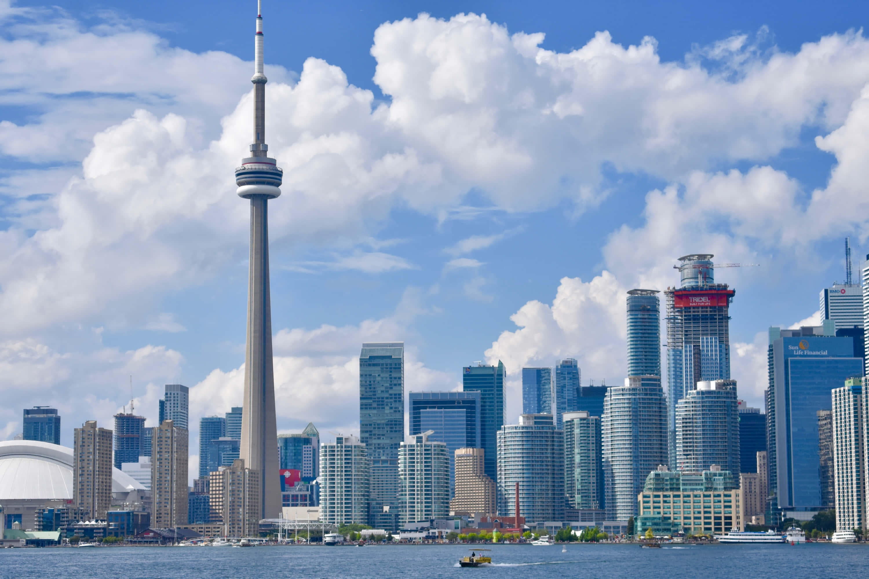Toronto Skyline 桌布 壁紙 — 多倫多地標CN塔和現代摩天大樓在蔚藍的天空和蓬鬆的白雲下聳立於海濱。