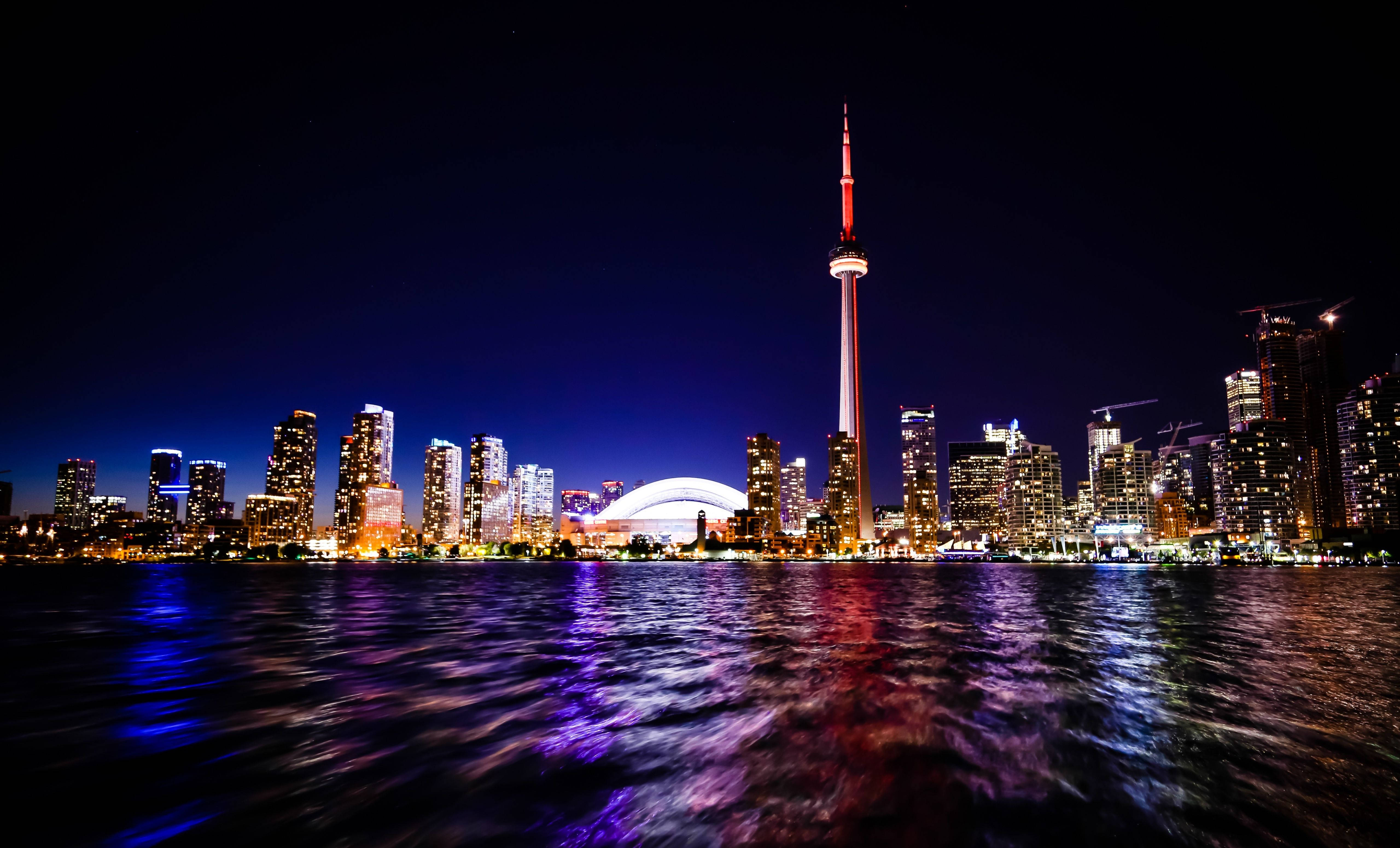 Ontario 桌布 壁紙 — 多倫多夜晚璀璨的天際線，CN塔在水面反射的光芒中閃耀。