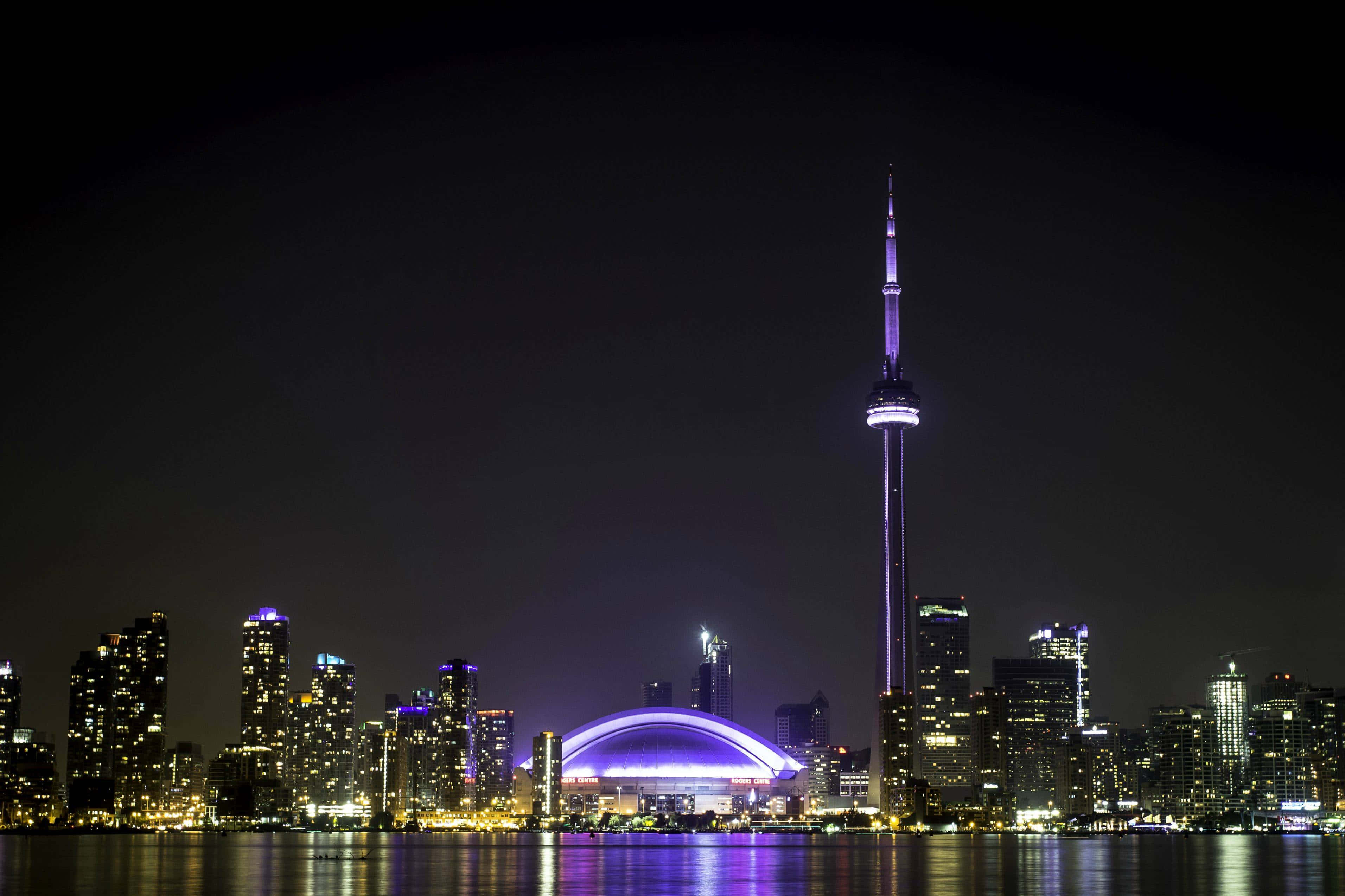 Toronto 桌布 壁紙 — 多倫多夜景，CN塔和羅傑斯中心在水面上閃耀著紫色和金色。