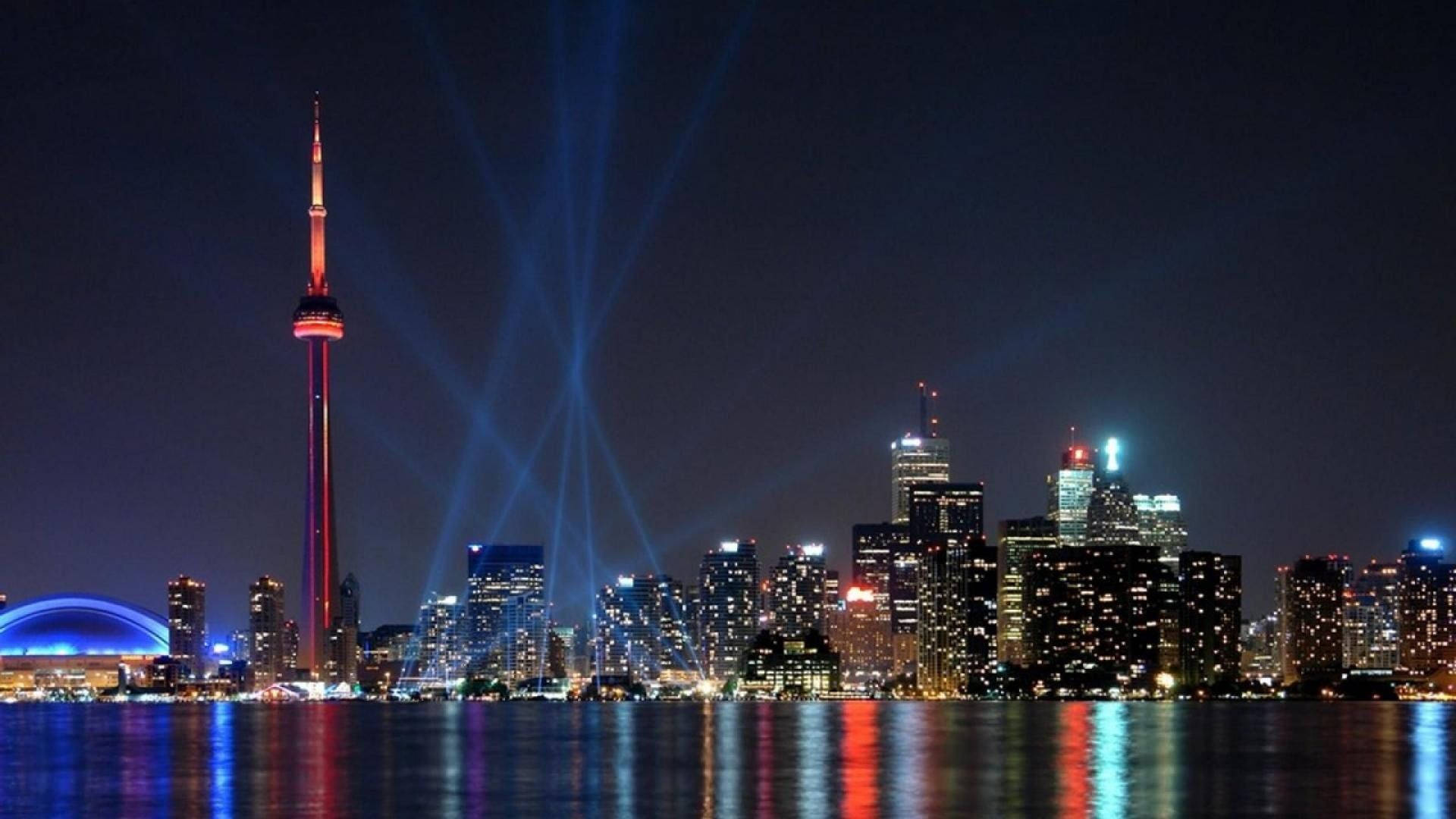 Toronto 桌布 壁紙 — 多倫多夜景，CN塔發出紅色光芒，藍色雷射射向水面上方的黑暗天空。