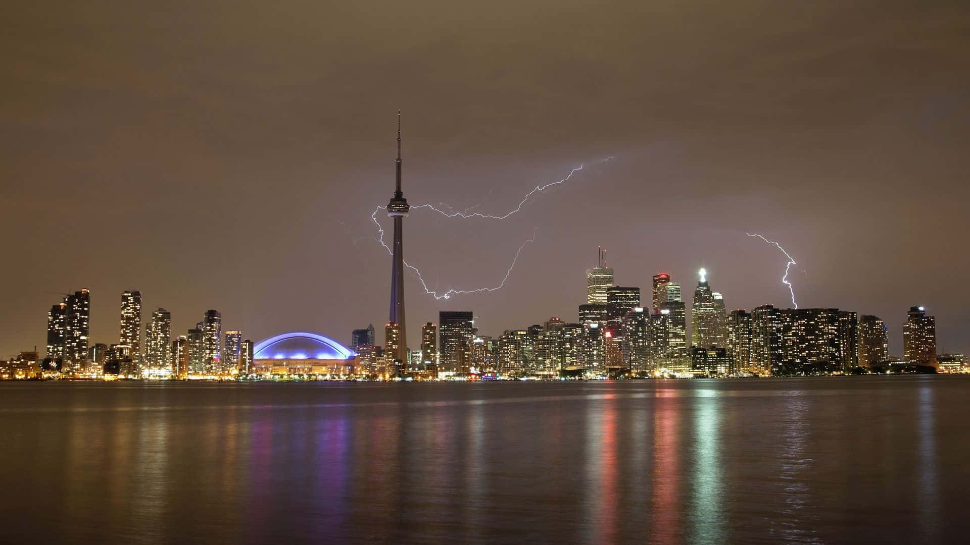 Toronto 桌布 壁紙 — 多倫多夜景，戲劇性的閃電照亮了CN塔，城市燈光倒映在水中。