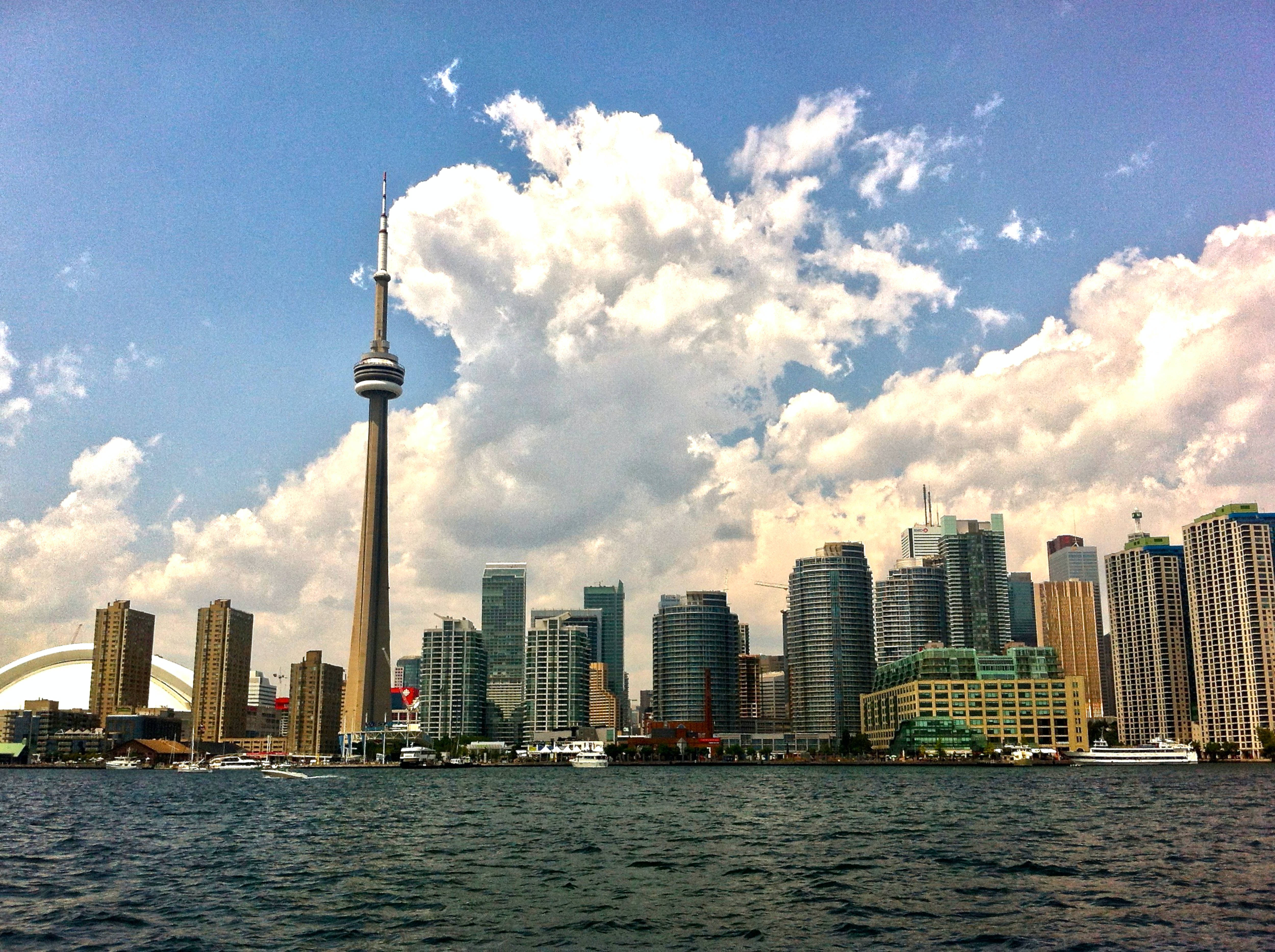 Ontario 桌布 壁紙 — 多倫多天際線，CN塔和現代摩天大樓在微風吹拂的水面上倒映，天空部分多雲。