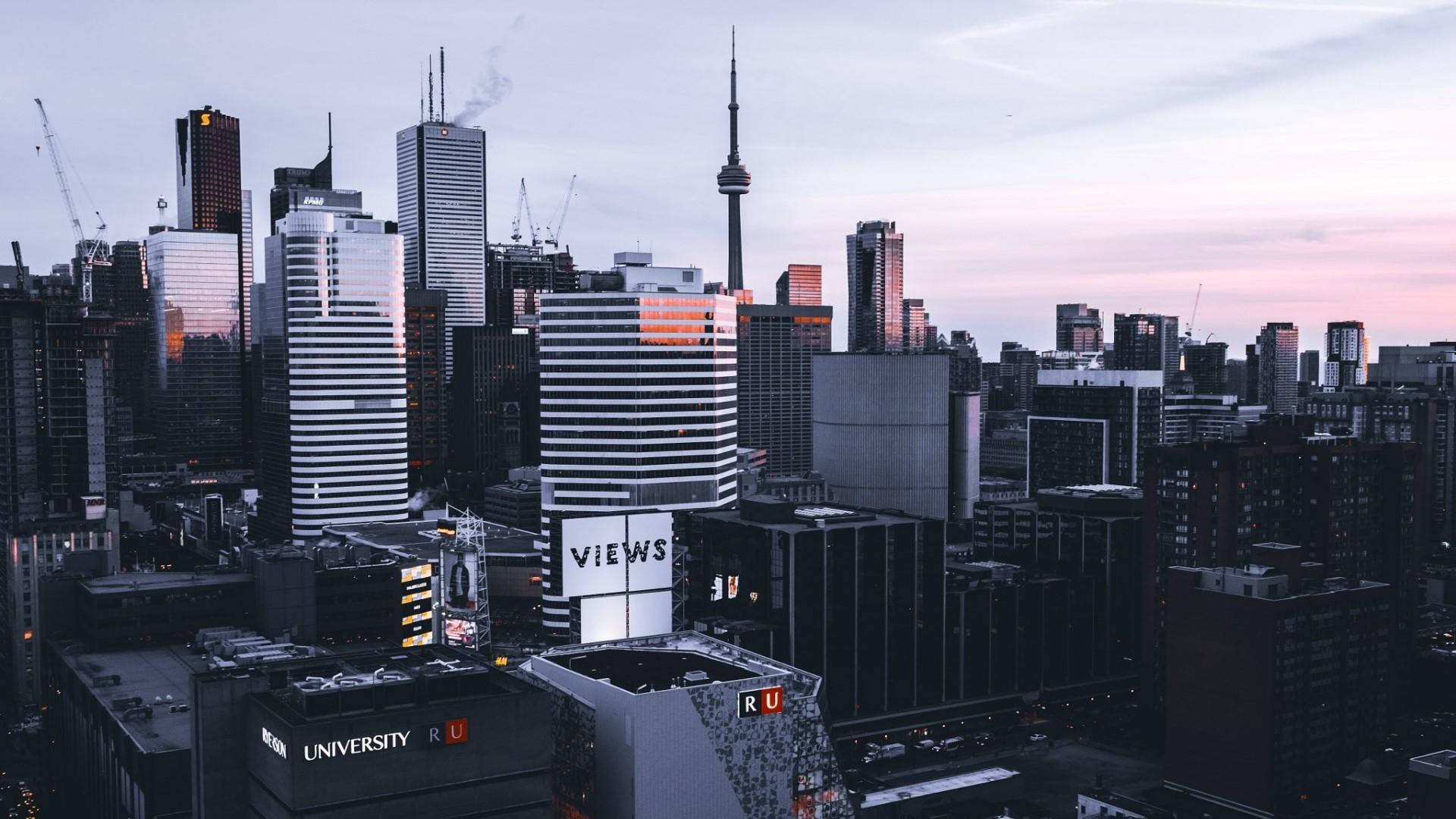Toronto 桌布 壁紙 — 多倫多天際線在黃昏時的全景，CN塔和現代摩天大樓沐浴在柔和的粉紅色和紫色暮色中。