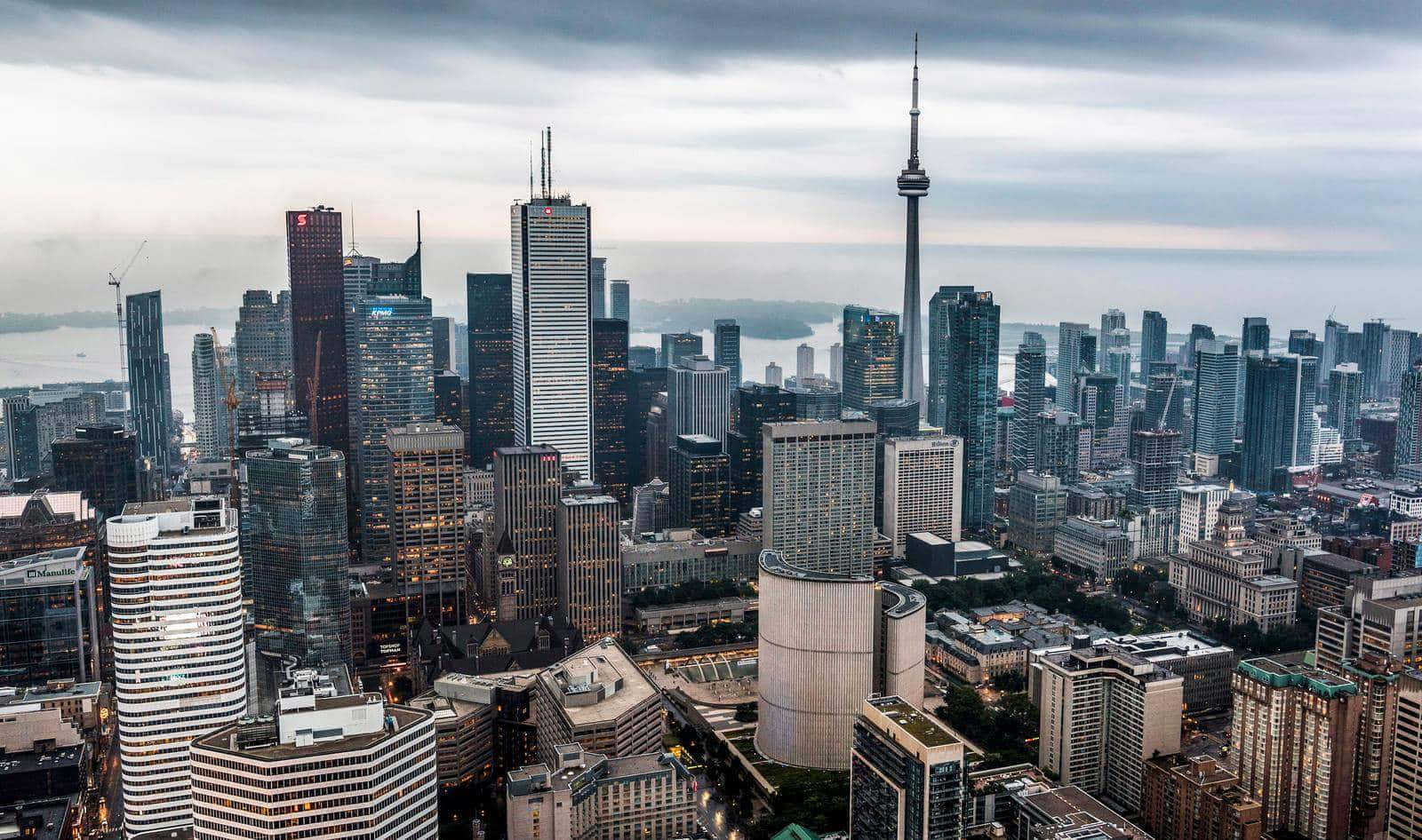 Toronto 桌布 壁紙 — 多倫多天際線在黃昏時的鳥瞰圖，CN 塔和玻璃摩天大樓反射著多雲的灰色天空。