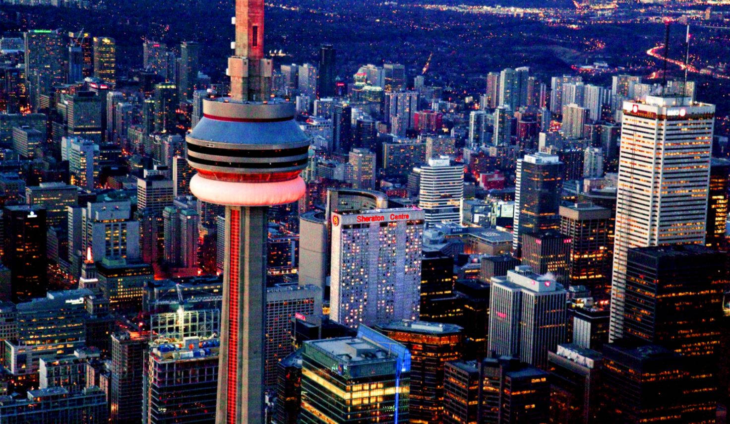 Ontario 桌布 壁紙 — 多倫多天際線在黃昏時的鳥瞰圖，CN塔發出紅光，城市燈光在下方閃爍。