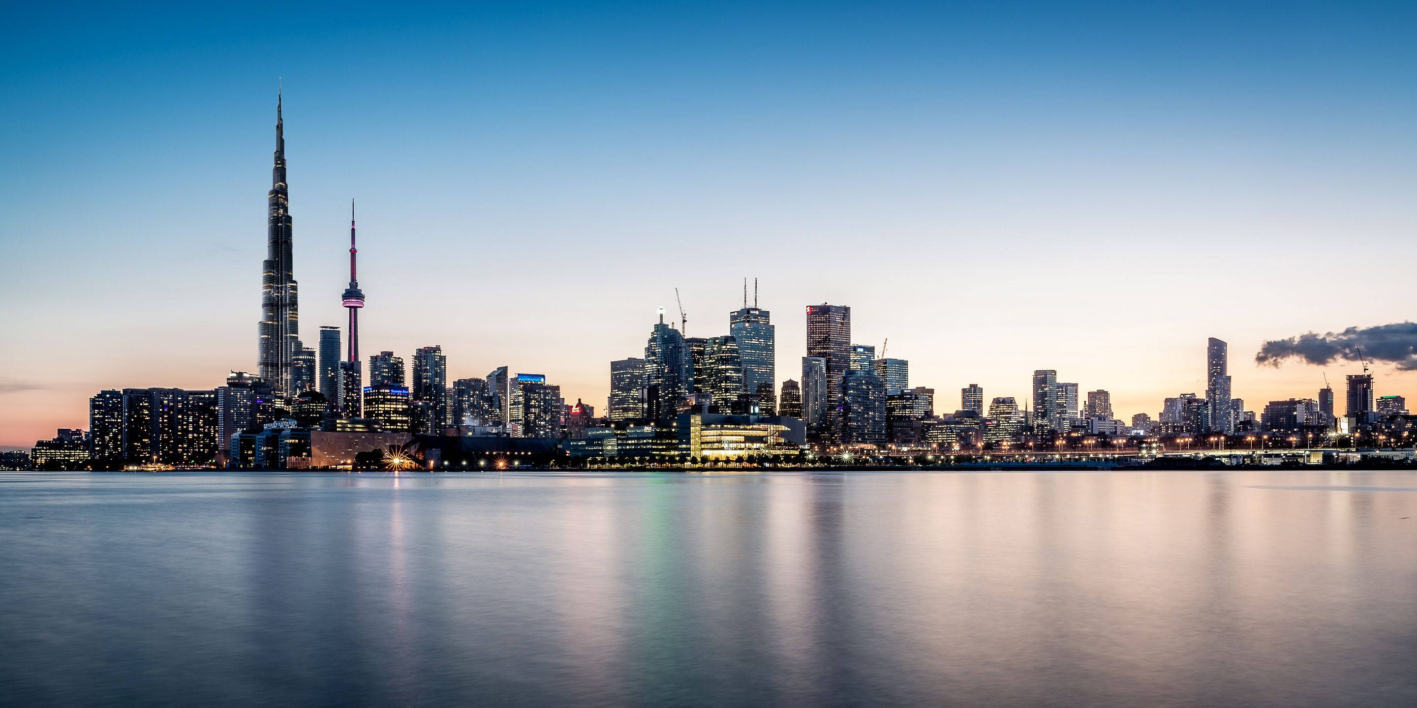 Toronto 桌布 壁紙 — 多倫多天際線的壯麗暮色景觀，CN 塔和摩天大樓倒映在平靜的水面上。