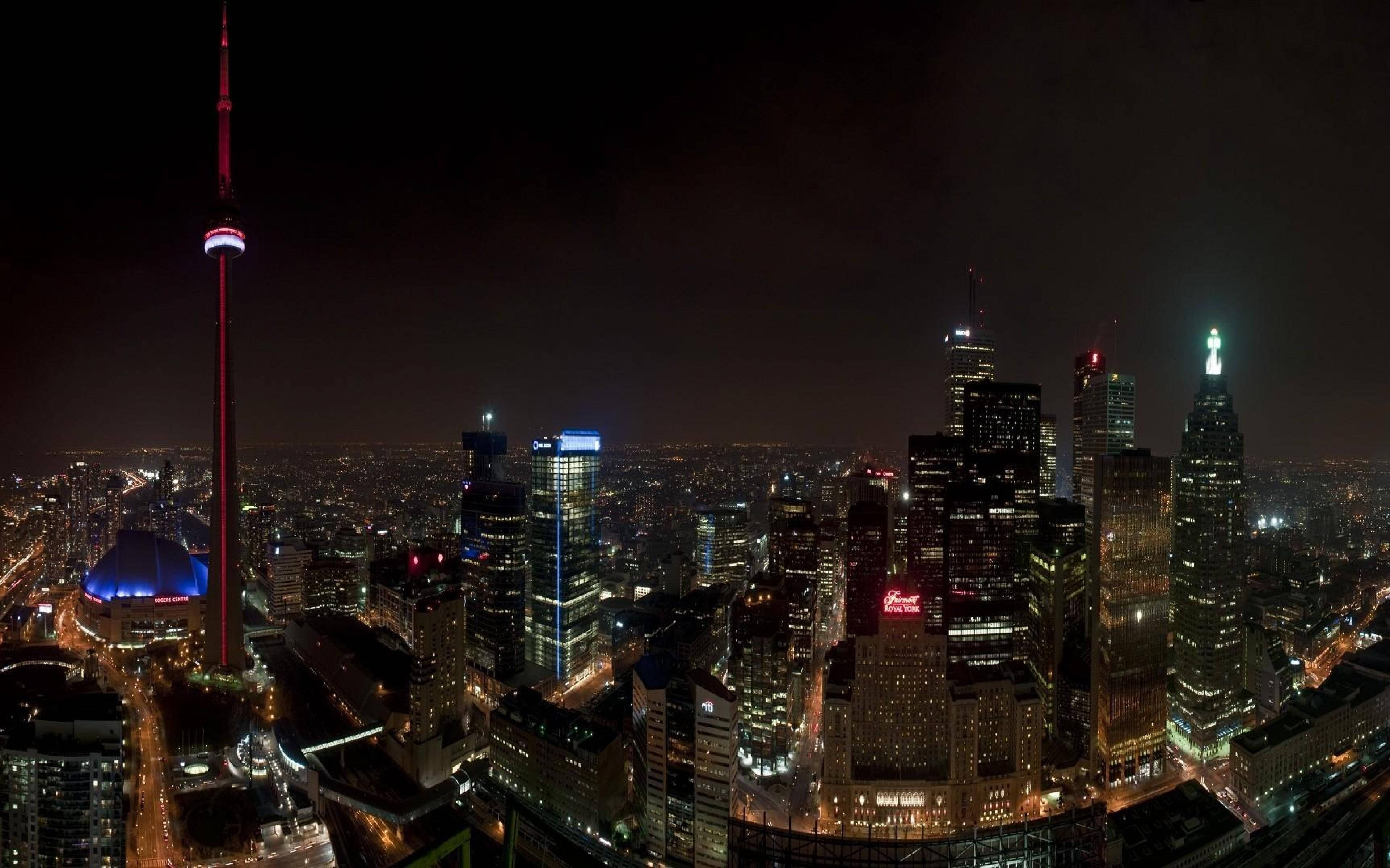 Toronto 桌布 壁紙 — 多倫多天際線的空中夜景，亮燈的CN塔和發光的摩天大樓映襯著黑暗的天空。