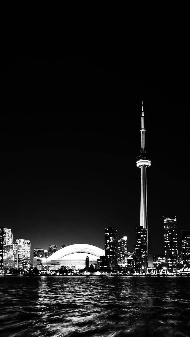 黑白 桌布 壁紙 — 多倫多天際線的醒目黑白夜景，標誌性的CN塔和燈火通明的摩天大樓倒映在漣漪的水面上。